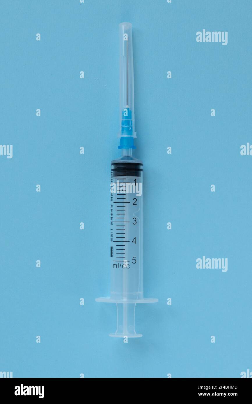 Seringue jetable isolée sur fond bleu. Santé et médecine. Banque D'Images