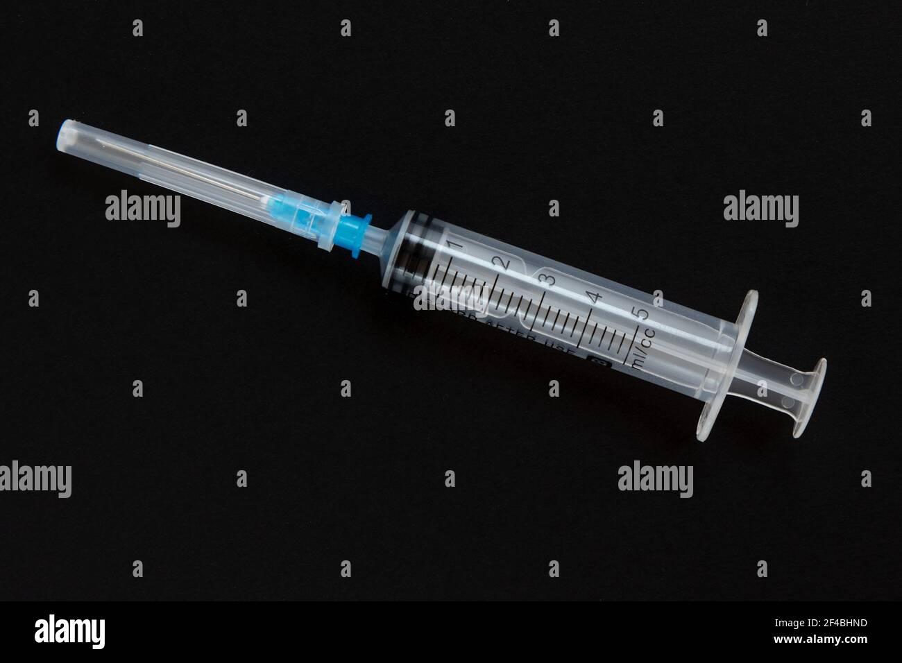 Seringue jetable isolée sur fond noir. Santé et médecine. Banque D'Images