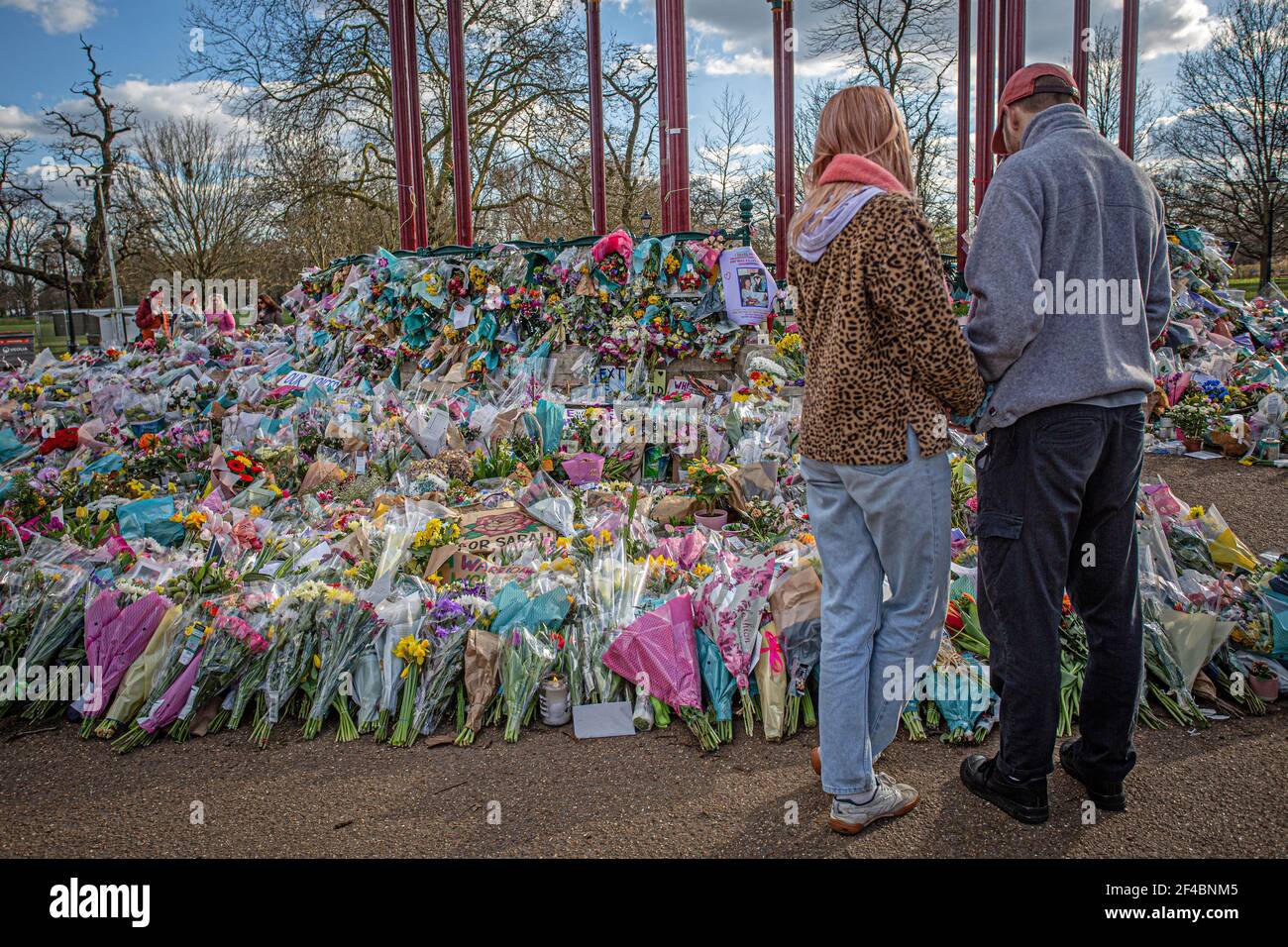 Un couple regarde les hommages floraux laissés au kiosque Clapham Common où les gens continuent de rendre leurs respects à Sarah Everard le 16 mars 2021 à Lo Banque D'Images