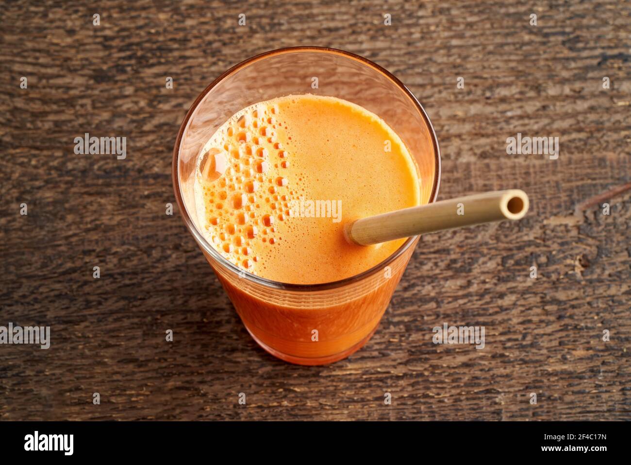 jus de carotte avec une paille de bambou écologique sur un rustique tableau Banque D'Images