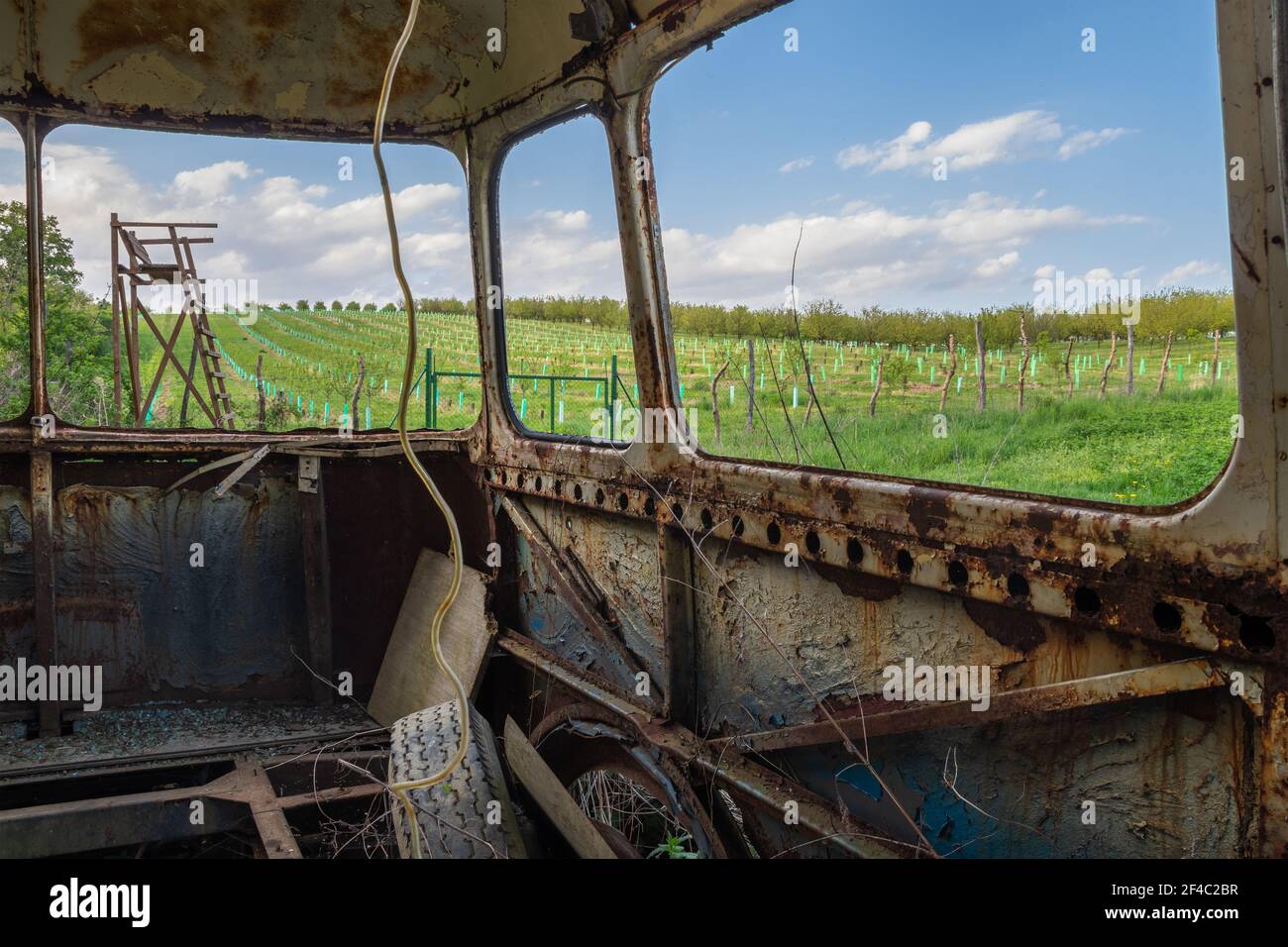 Vue sur un vieux bus rouillé sur un paysage de printemps avec tour de surveillance. Dommages environnementaux. Banque D'Images