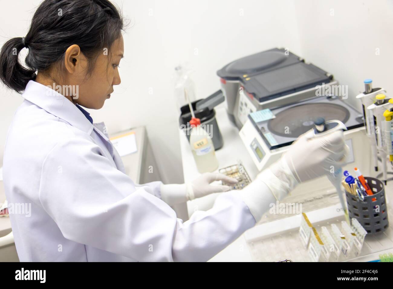 Une femme travaillant avec une pipette pour le sang de test dans un laboratoire à l'hôpital Banque D'Images