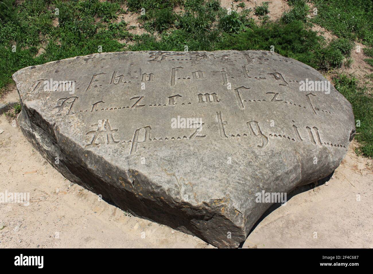 Ancienne inscription codée gravée par police gothique avec lettres manquantes sur un gros bloc, cette roche est mieux connue comme la pierre des Templiers selon Banque D'Images