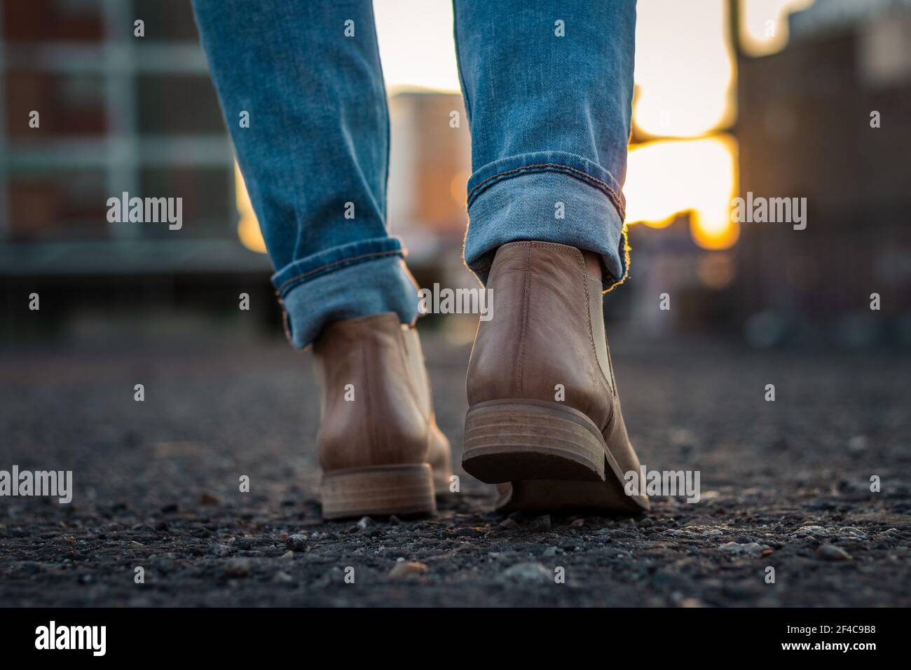 Femme portant un Jean et une chaussure en cuir marchant en ville au coucher  du soleil. Vue rapprochée de l'arrière des chaussures Photo Stock - Alamy
