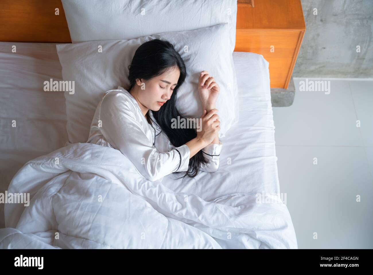 Vue de dessus d'une jolie jeune femme asiatique qui dormait bien dans le lit. Adolescente au repos, concept de bonne nuit de sommeil. Banque D'Images