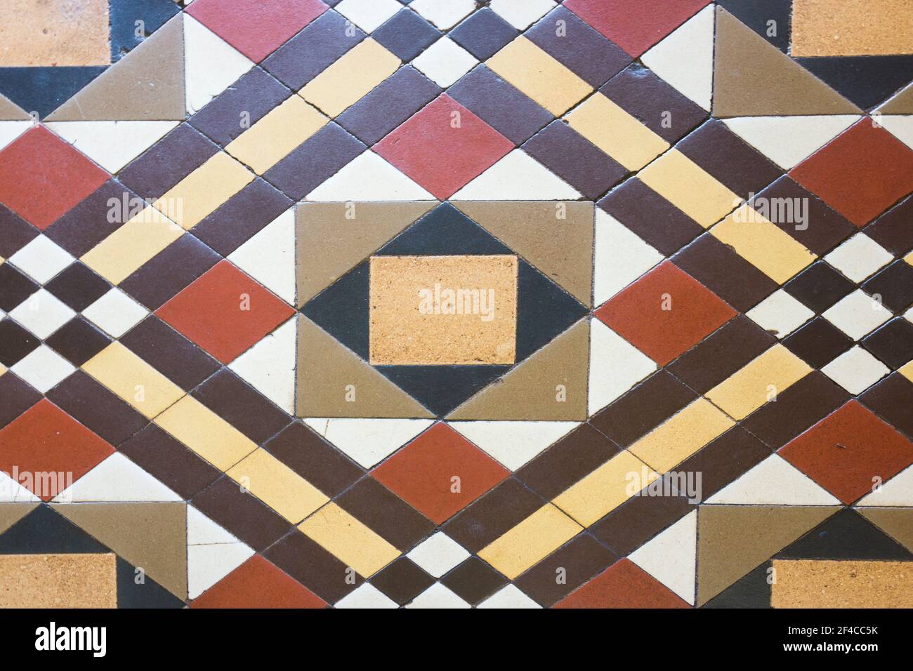 Carreaux de l'époque victorienne dans un motif géométrique de couleur rouille brun crème blanc jaune noir à l'entrée d'un vieux magasin dans une ville de campagne du Queensland, Banque D'Images