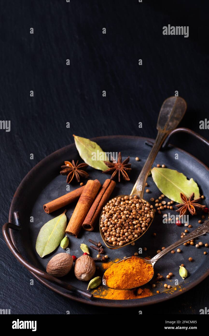 Spot focus Exotic Herbal Food concept mélange des épices bio graines de coriandre, clou de girofle, bâton de cannelle, gousses de cardamome, feuilles de Laurier, anis étoilé rustique Banque D'Images