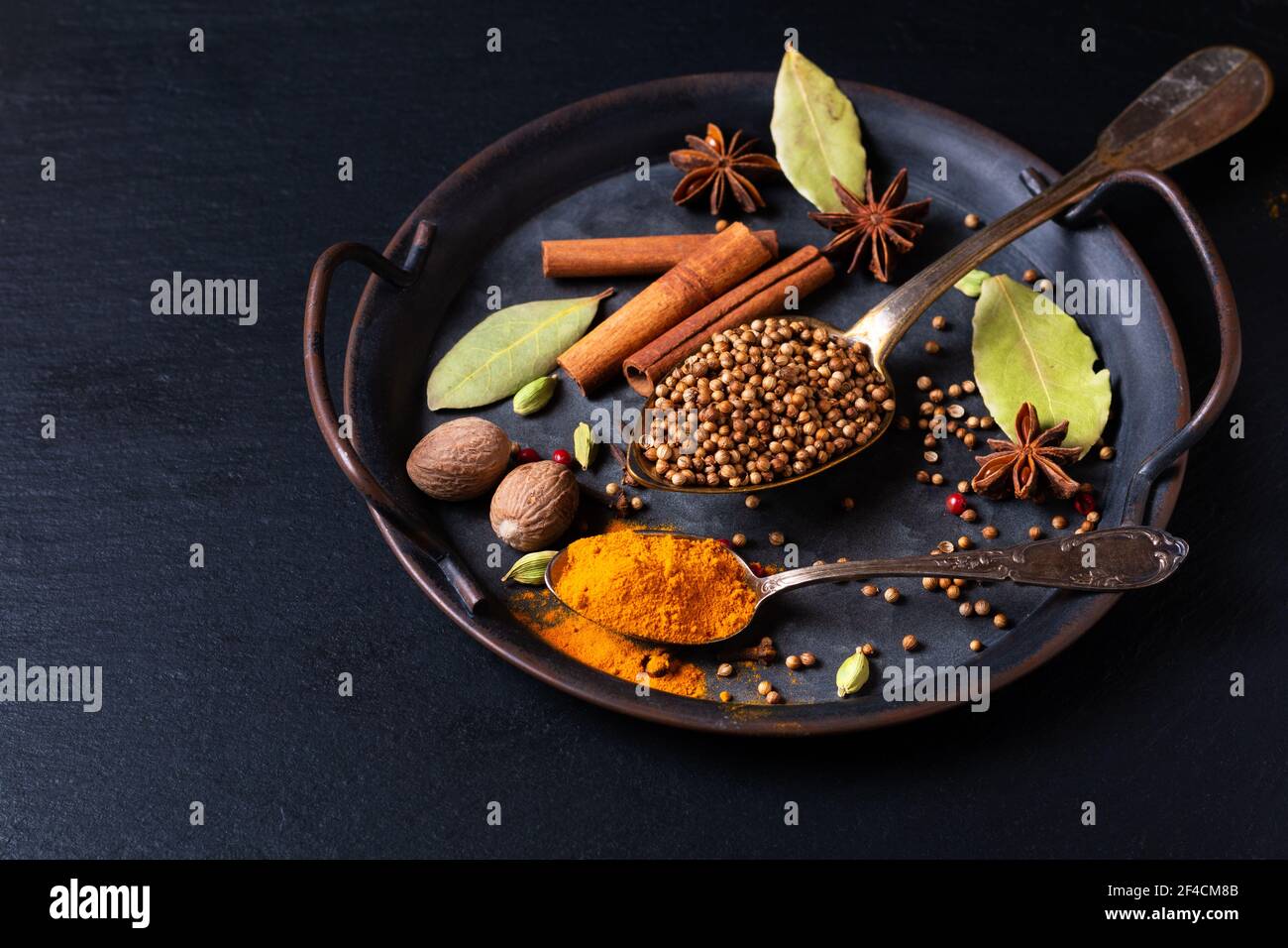 Spot focus Exotic Herbal Food concept mélange des épices bio graines de coriandre, clou de girofle, bâton de cannelle, gousses de cardamome, feuilles de Laurier, anis étoilé rustique Banque D'Images