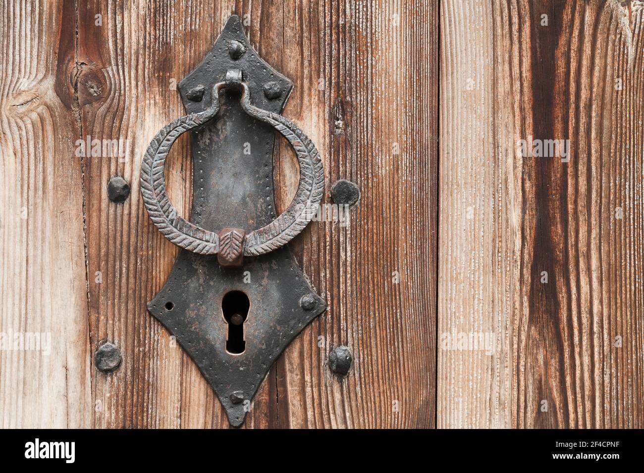 Ancienne serrure forgée et bague de perçage sur une ancienne porte en bois, photo rapprochée Banque D'Images