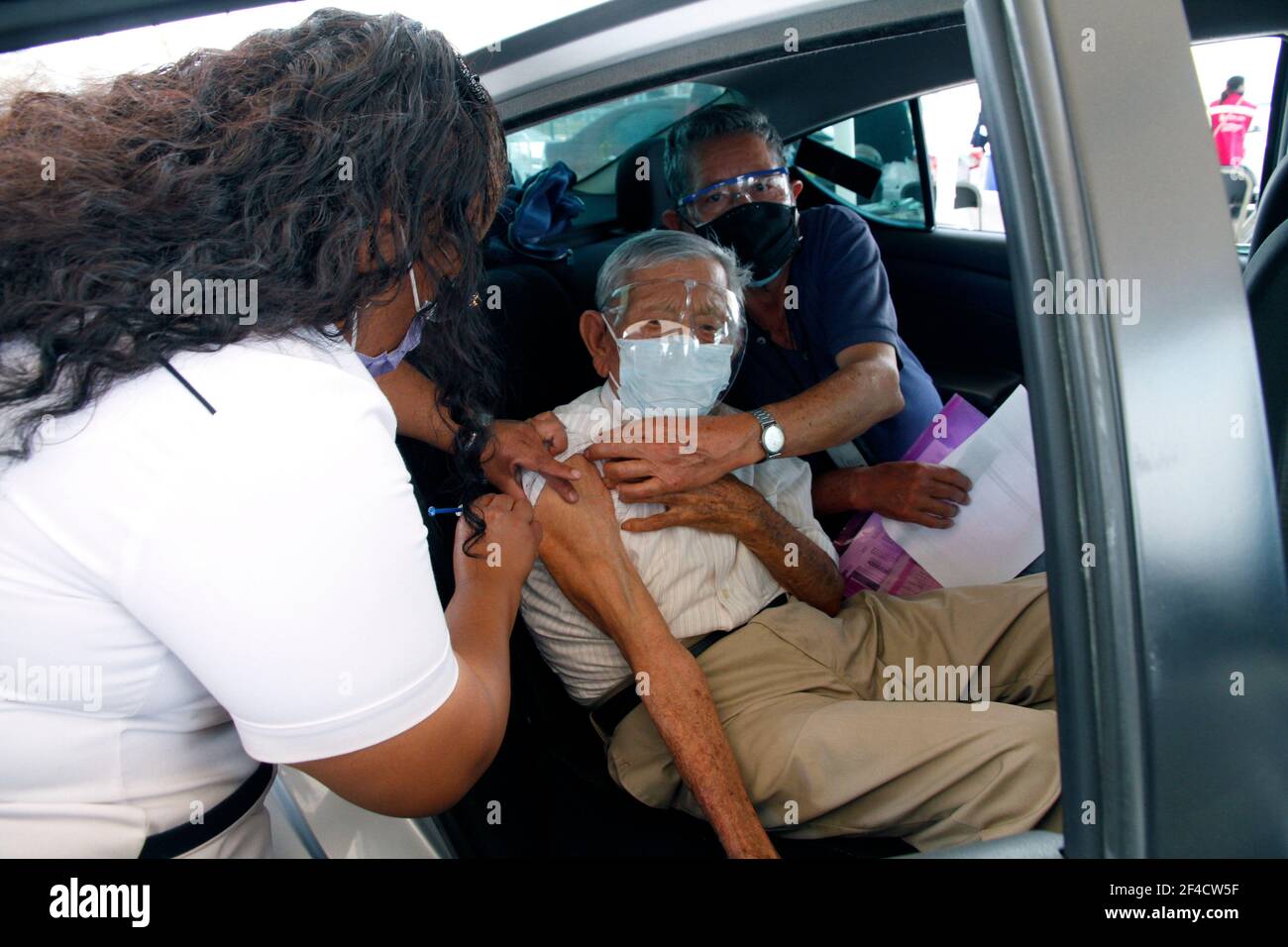 Nezahualcoyotl City, Mexique. 19 mars 2021. NEZAHUALCOYOTL CITY, MEXIQUE - MARS 19 : un agent de santé injecte un vaccin Sinovac Covid19 à une personne âgée à l'intérieur d'une voiture au Sports City Garden, dans la municipalité de Nezahualcoyotl dans l'État du Mexique, dans le cadre d'un programme d'immunisation des conducteurs contre Covid19. Le 19 mars 2021 à Nezahualcoyotl City, Mexique. (Photo d'Eyepix/Sipa USA) crédit: SIPA USA/Alay Live News Banque D'Images