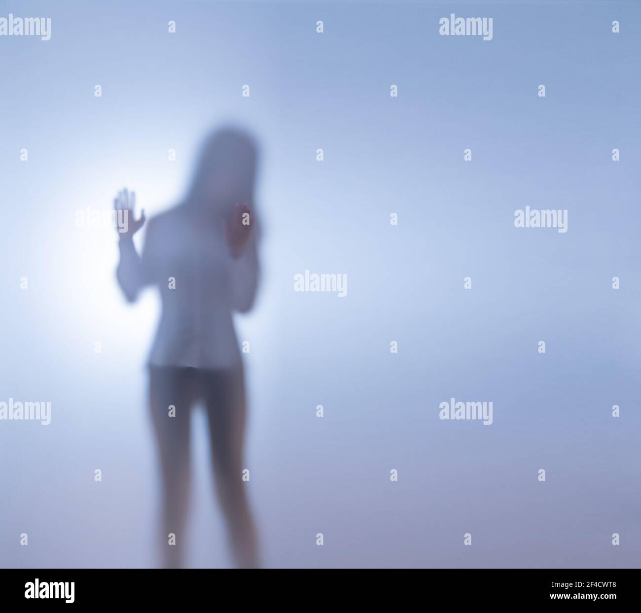 Une jeune femme se tient derrière un verre dépoli. Le concept d'enlèvement et de les garder en captivité Banque D'Images