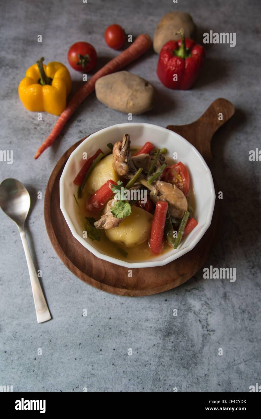 Aliments sains poulet ragoût et légumes dans un bol et condiments crus Banque D'Images