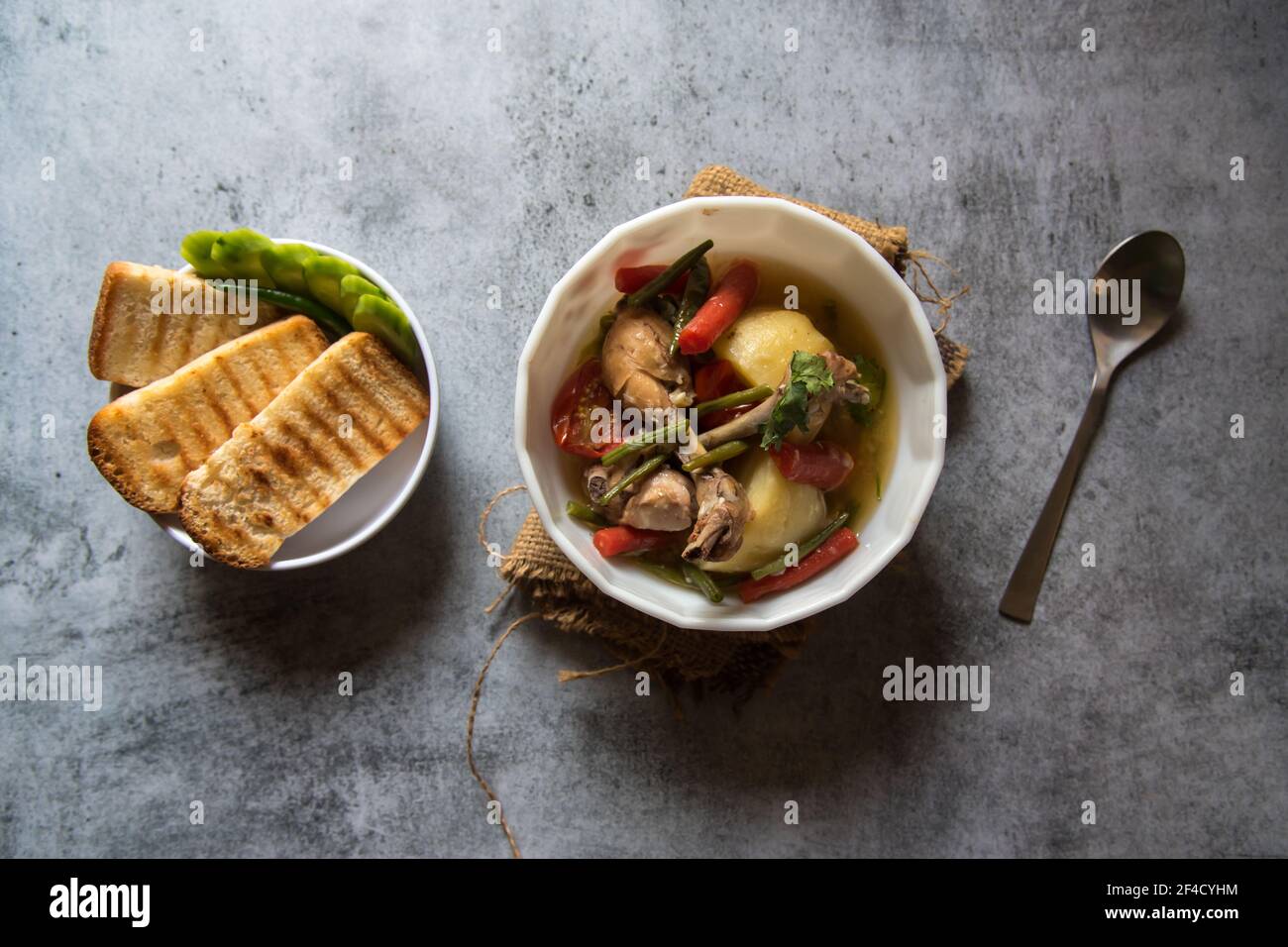 Ragoût de poulet et légumes dans un bol et tranches de pain Banque D'Images