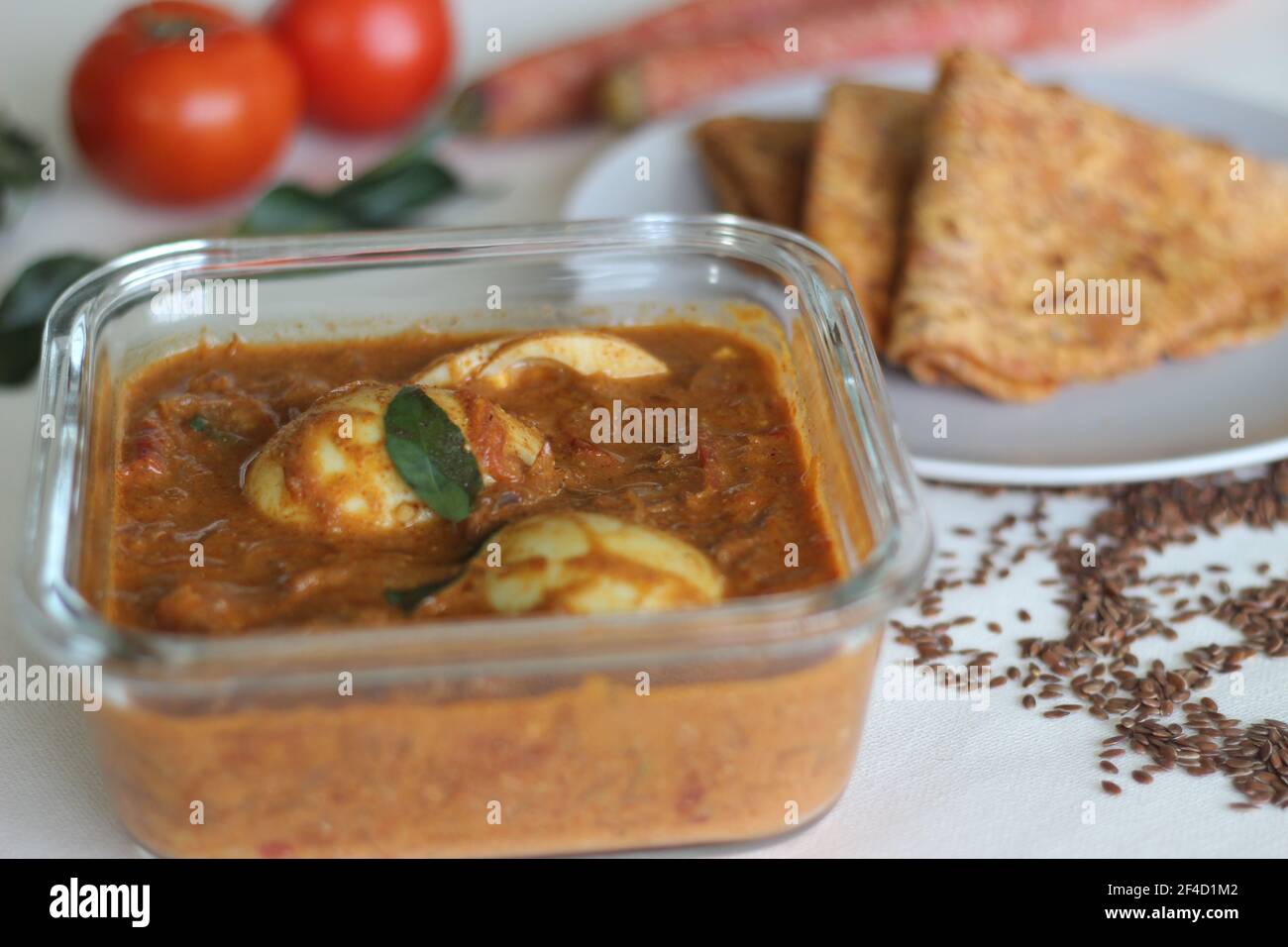 Curry aux œufs durs, sauce à base de noix de cajou et de tomate servie avec du pain plat indien de blé entier fait de carottes râpées et de graines de lin en poudre. Prise de vue sur W Banque D'Images