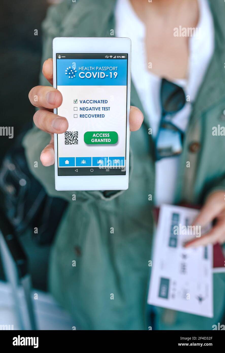 Femme montrant un passeport covid sur le smartphone à un aéroport con Banque D'Images