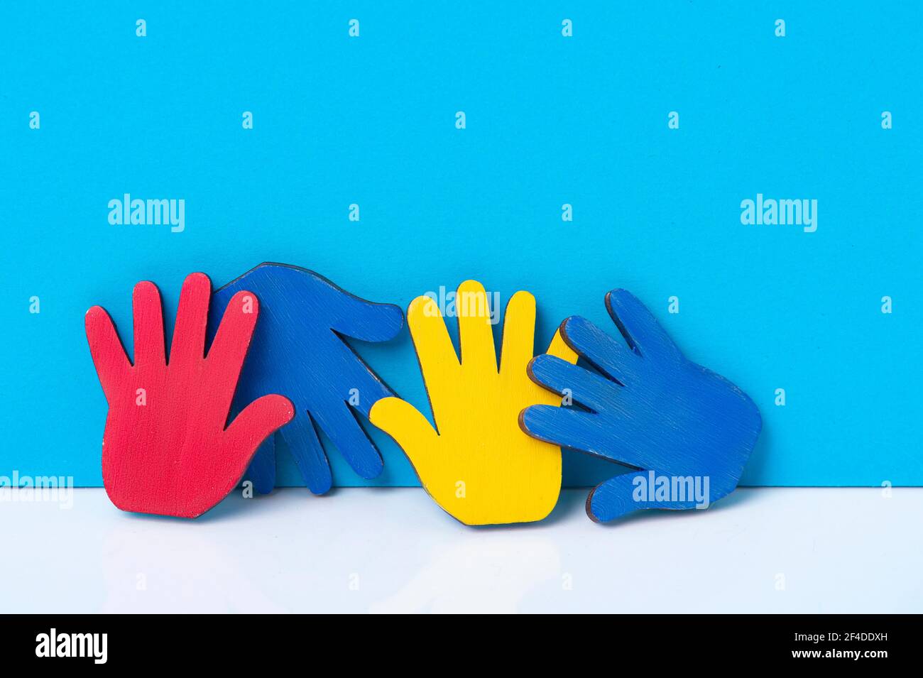 Colourfull puzzles mains sur fond bleu. Journée mondiale de sensibilisation à l'Autisme Concept Banque D'Images