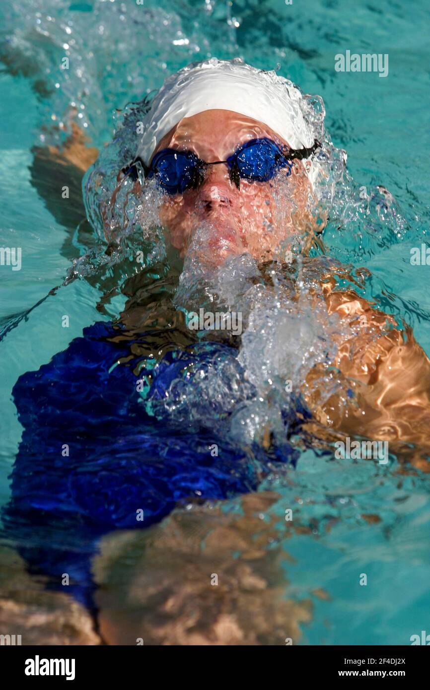 Une femme nage le dos pendant une rencontre de natation en plein air. Banque D'Images