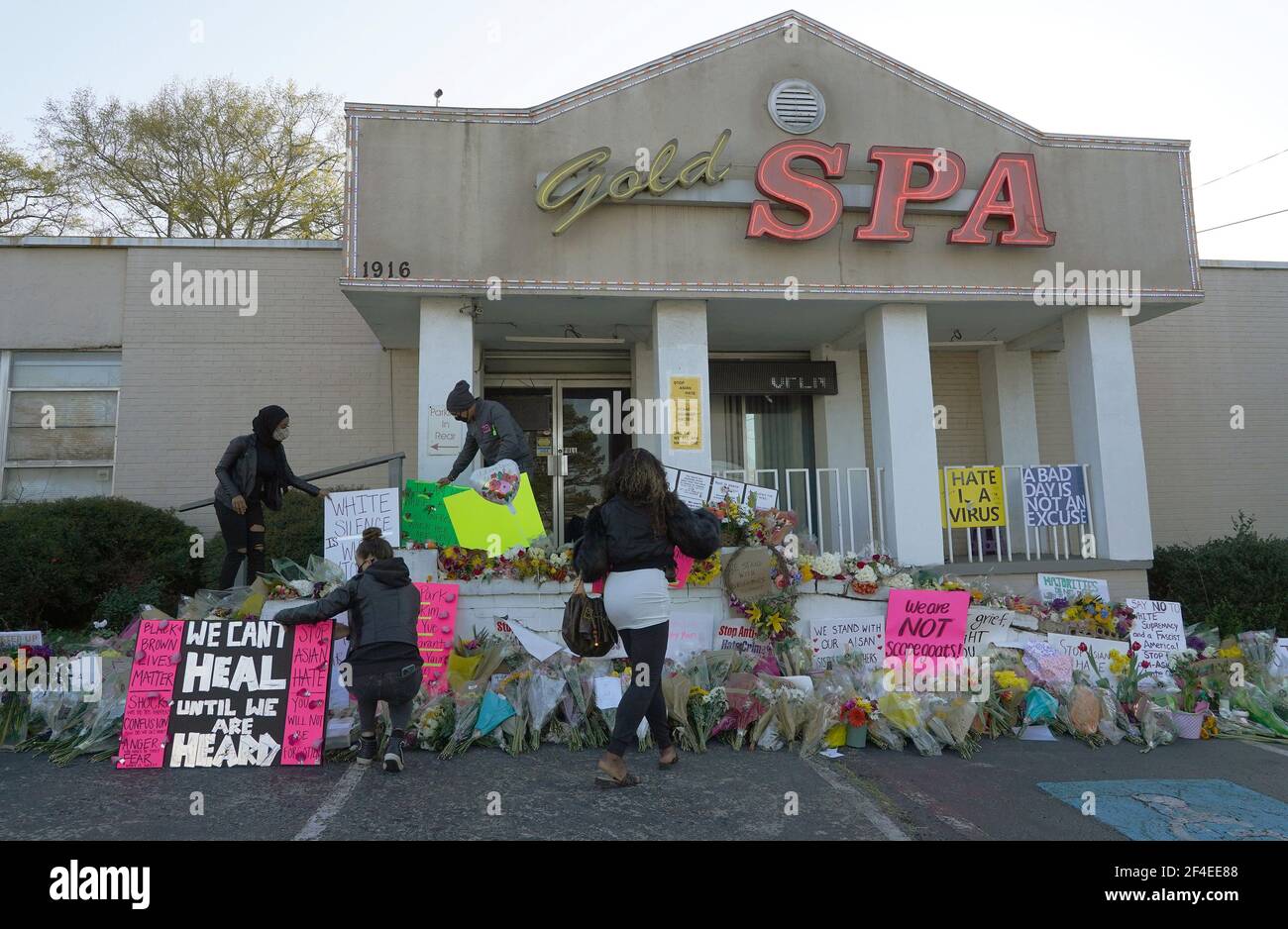 Atlanta, États-Unis. 20 mars 2021. Un groupe de personnes place des panneaux au mémorial de fortune devant le Gold Spa après les fusillades meurtrières qui ont tué huit personnes dans trois spas différents à Atlanta, en Géorgie, le 20 mars 2021. Photo de Tami Chappell/UPI crédit: UPI/Alay Live News Banque D'Images