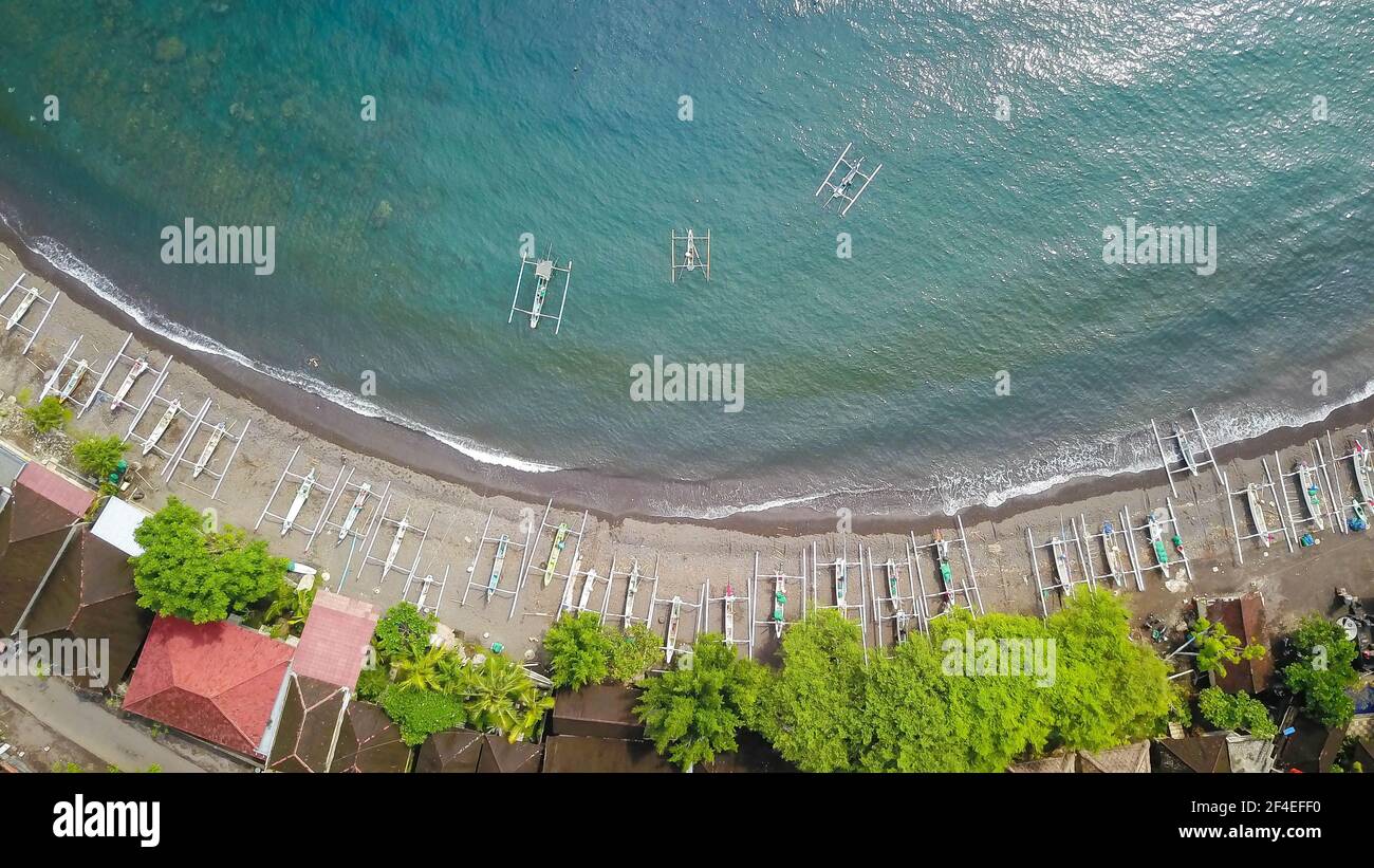 Vue aérienne de haut en bas des bateaux de pêche indonésiens traditionnels appelés jukung sur la plage de sable noir. À Amed, Bali, Indonésie Banque D'Images