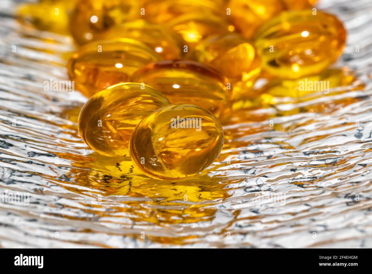 Capsules huile de poisson jaune sommeil fond gris. Banque D'Images