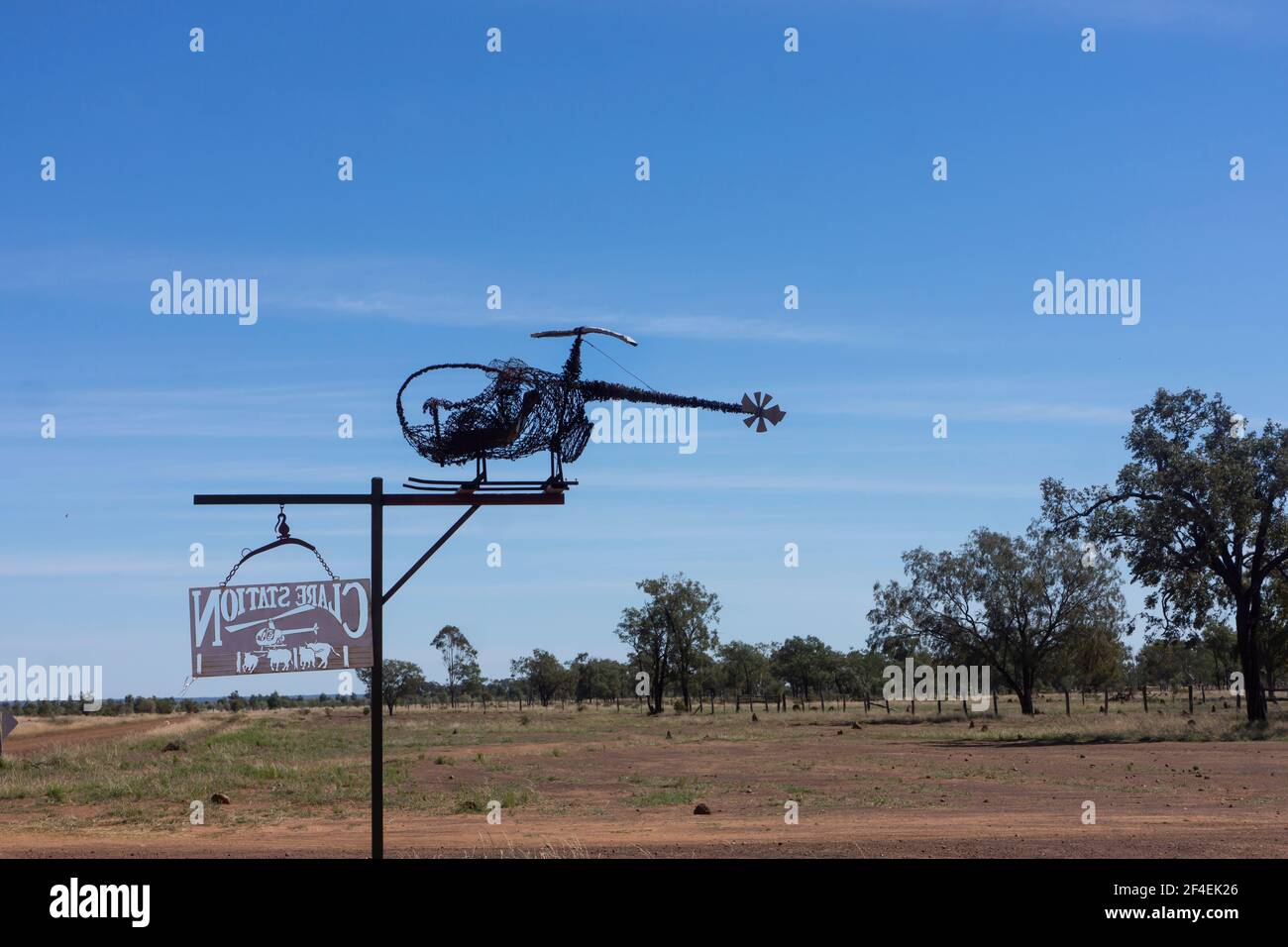 Une sculpture en ferraille d'un hélicoptère en fil barbelé au-dessus d'un panneau de propriété de station dans le Queensland arrière sur le sentier d'art du lac Dunn. Banque D'Images