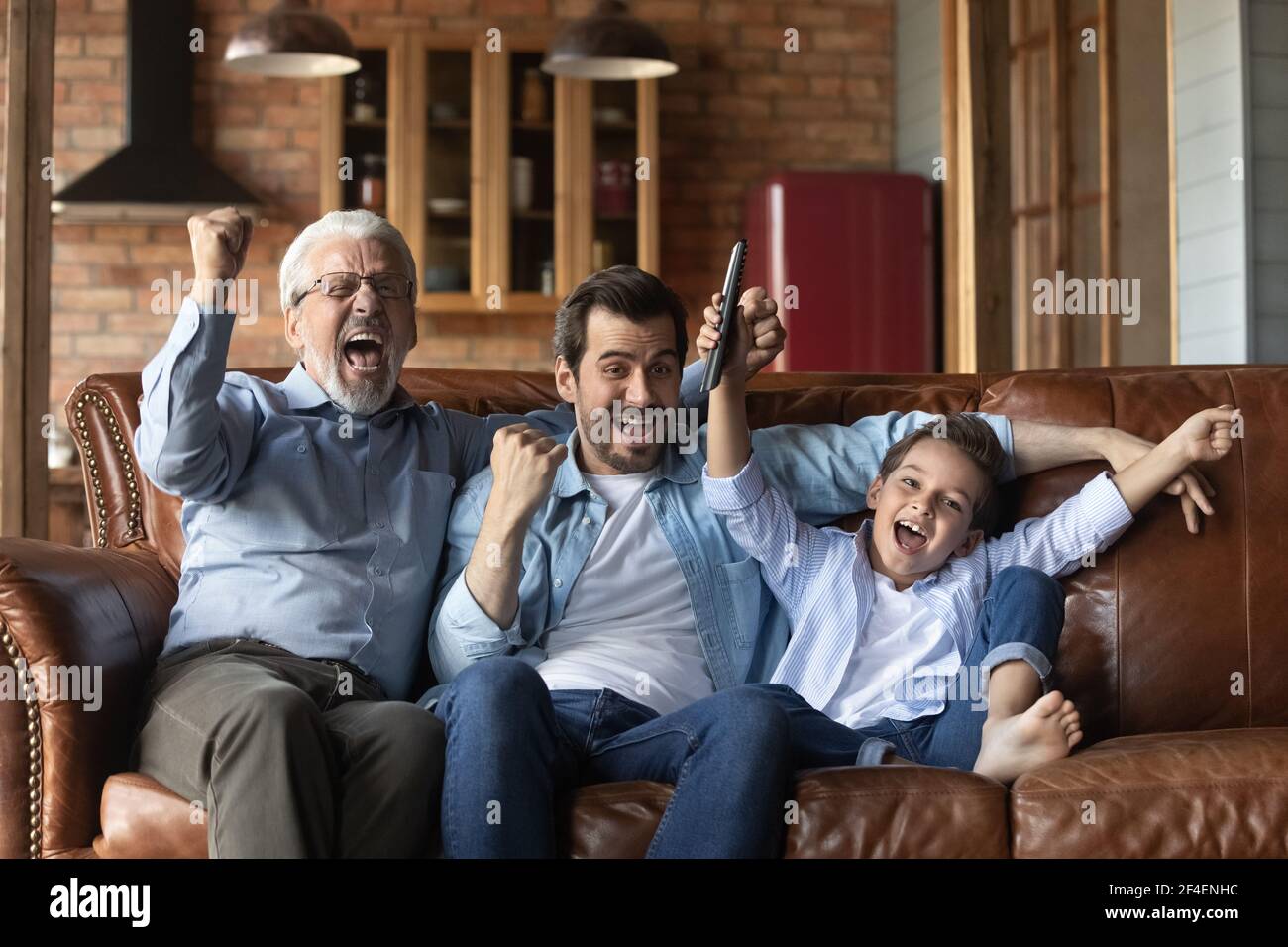 Trois générations d'hommes se réjouissèrent de la victoire du match Banque D'Images