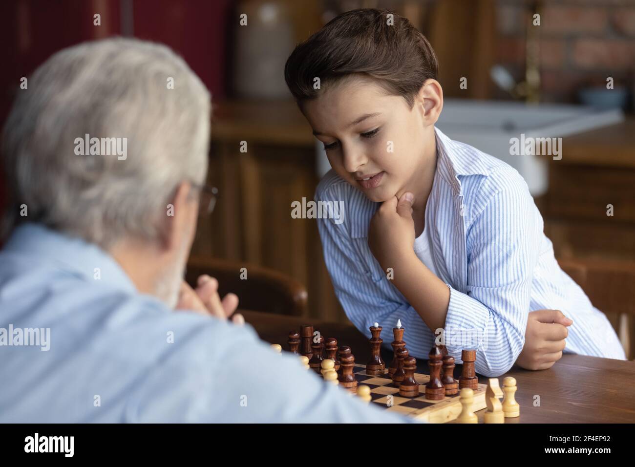 Petit-fils Smart 8s jouer aux échecs avec le vieux grand-père Banque D'Images