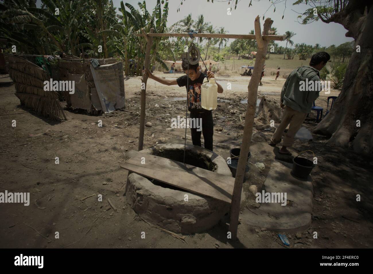 Un jeune homme qui prend l'eau d'un puits d'eau commun à Kawangu, Sumba, une île sèche à Nusa Tenggara, Indonésie. Selon ONU eau dans leur Résumé Progress Update 2021, qui a publié le 1 mars 2021 à Genève, 4,2 milliards de personnes, soit 55% de la population mondiale, n'avaient pas de services d'assainissement gérés en toute sécurité, en 2017, 3 milliards de personnes, soit 40 % de la population mondiale, n'avaient pas d'installation de base de lavage des mains avec du savon et de l'eau. Banque D'Images