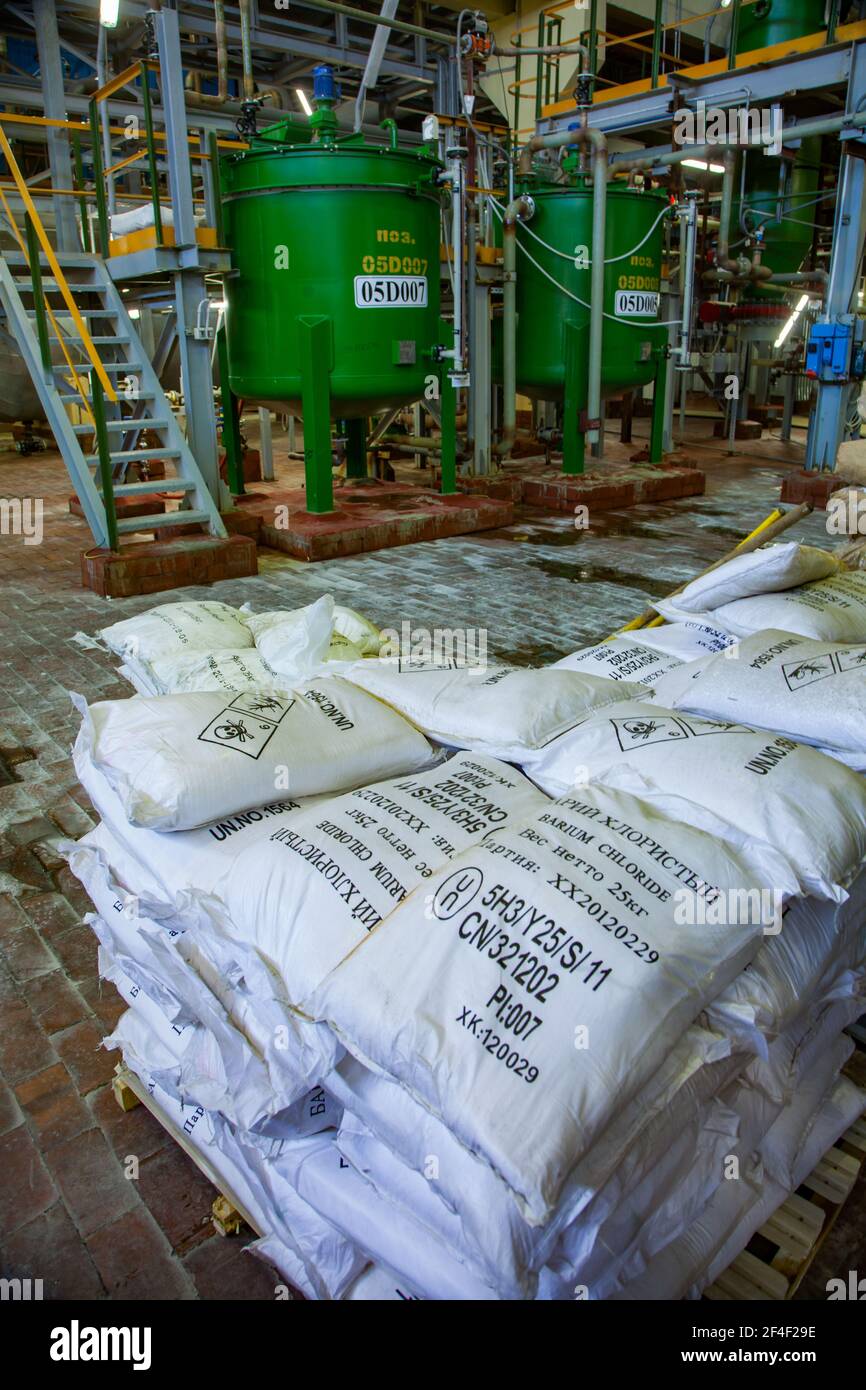 Usine chimique caustique. Sacs en plastique avec chlorure de baryum. Réacteur chimique en arrière-plan. Titre sur les sacs: Chlorure de baryum Banque D'Images