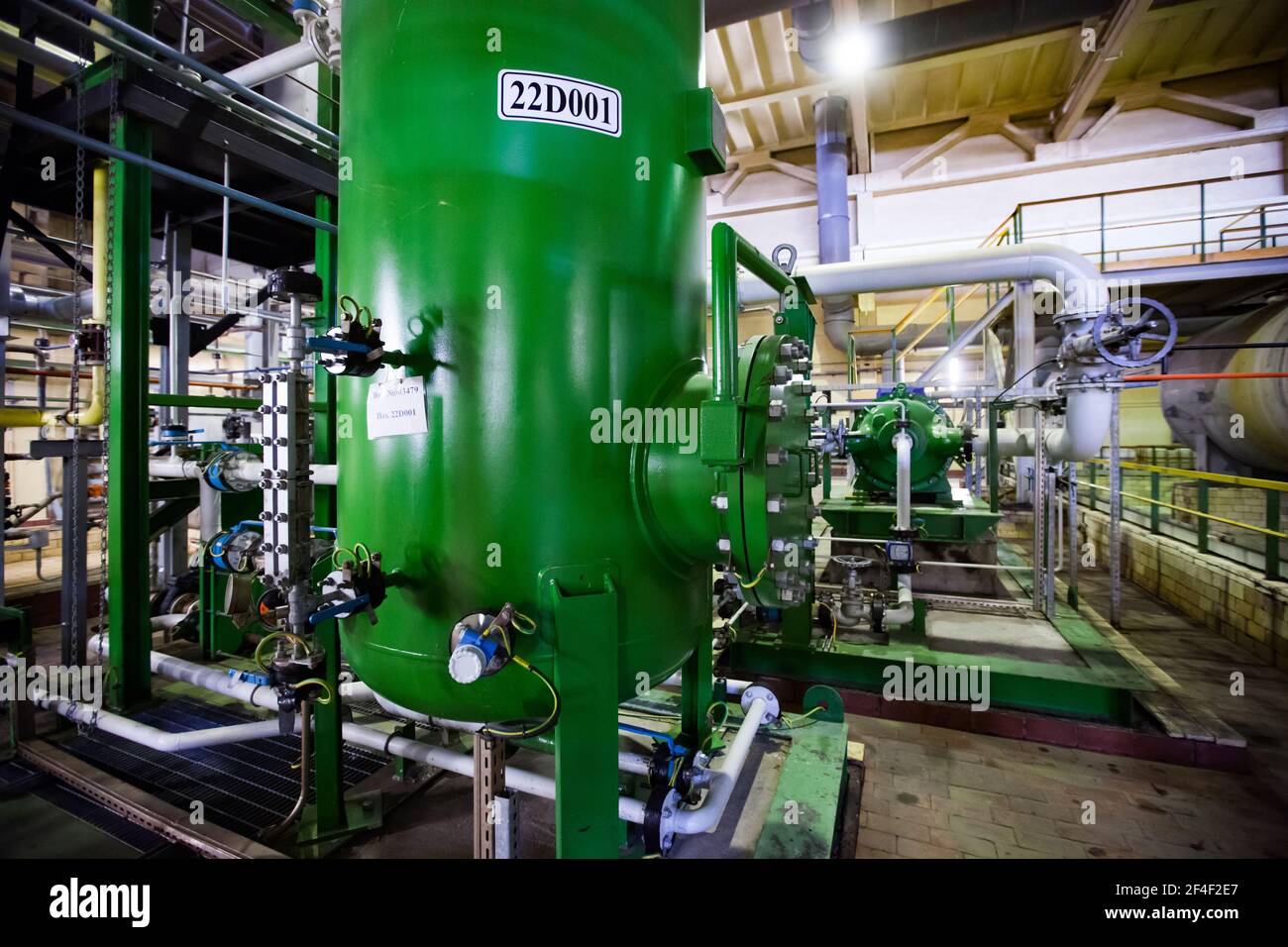 Atelier d'usine de produits chimiques caustiques. Réservoir en acier vert de réacteur chimique et de pipelines. Banque D'Images