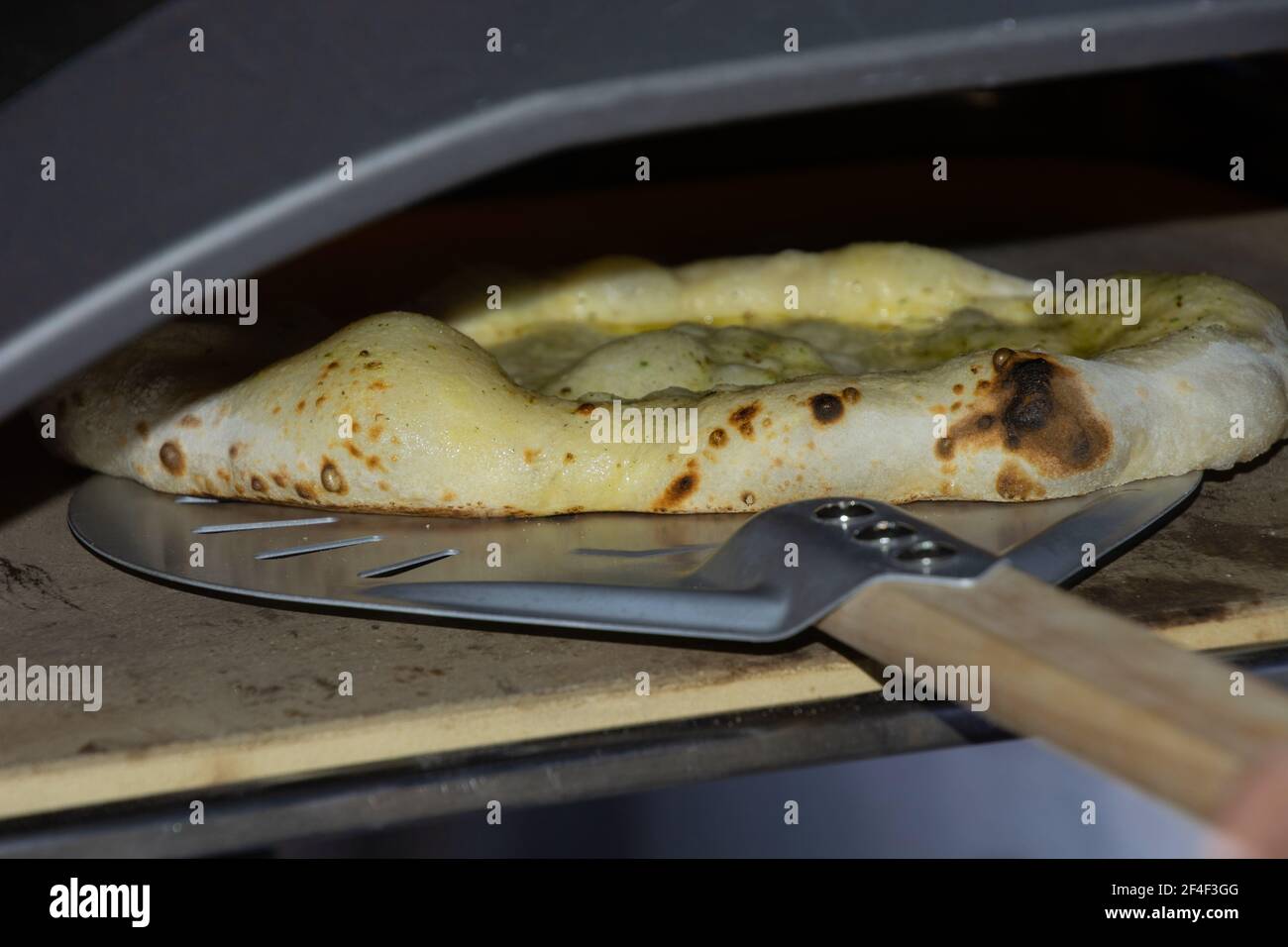 four à pizza avec feu brillant et à l'intérieur sur un pizza cuite au four à pain Banque D'Images