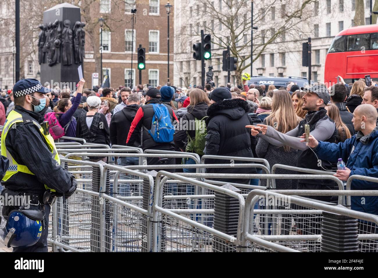 Des manifestants crient devant un policier isolé à l'extérieur de Downing Street lors d'une marche de protestation anti-verrouillage COVID 19 à Westminster, Londres, Royaume-Uni Banque D'Images