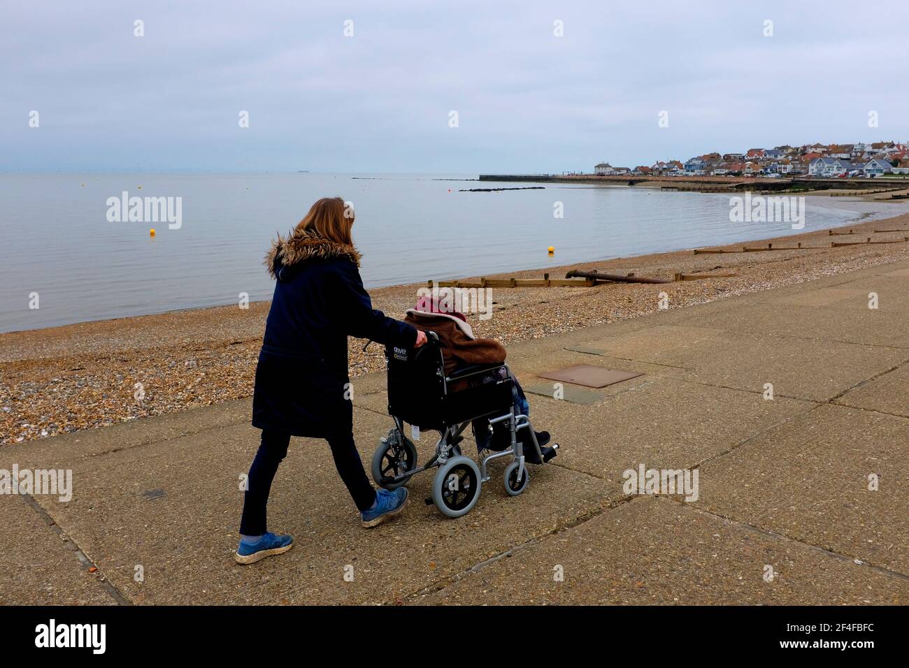 femme poussant un fauteuil roulant avec une femme handicapée assise hampton-on-sea est kent royaume-uni mars 2021 Banque D'Images