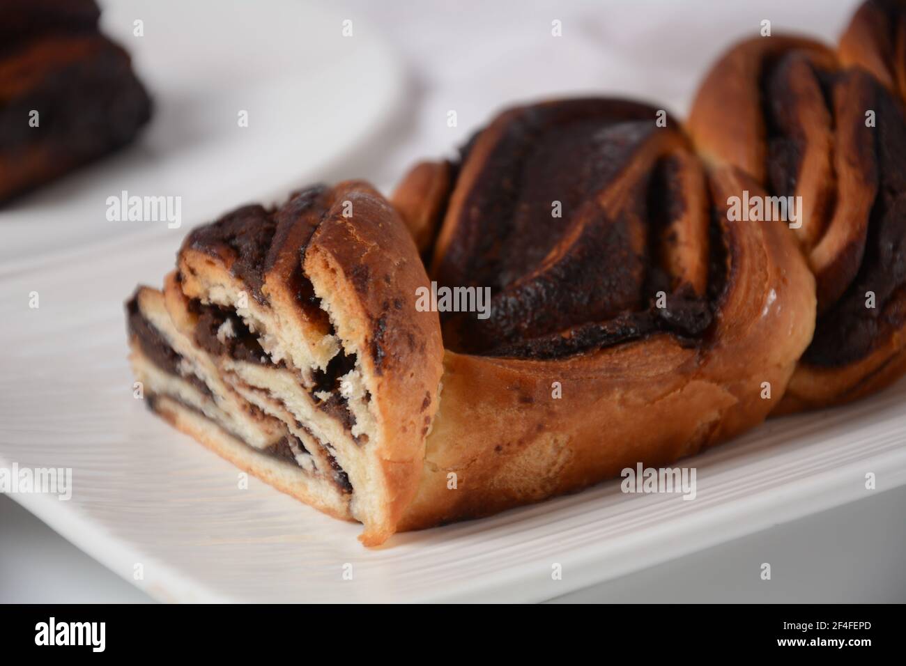 Pain Babka ou Brioche. Farci de crème de noisettes. Gâteau traditionnel juif semblable à du pain, recouvert de chocolat ou de cannelle et recouvert de nuggets de Banque D'Images