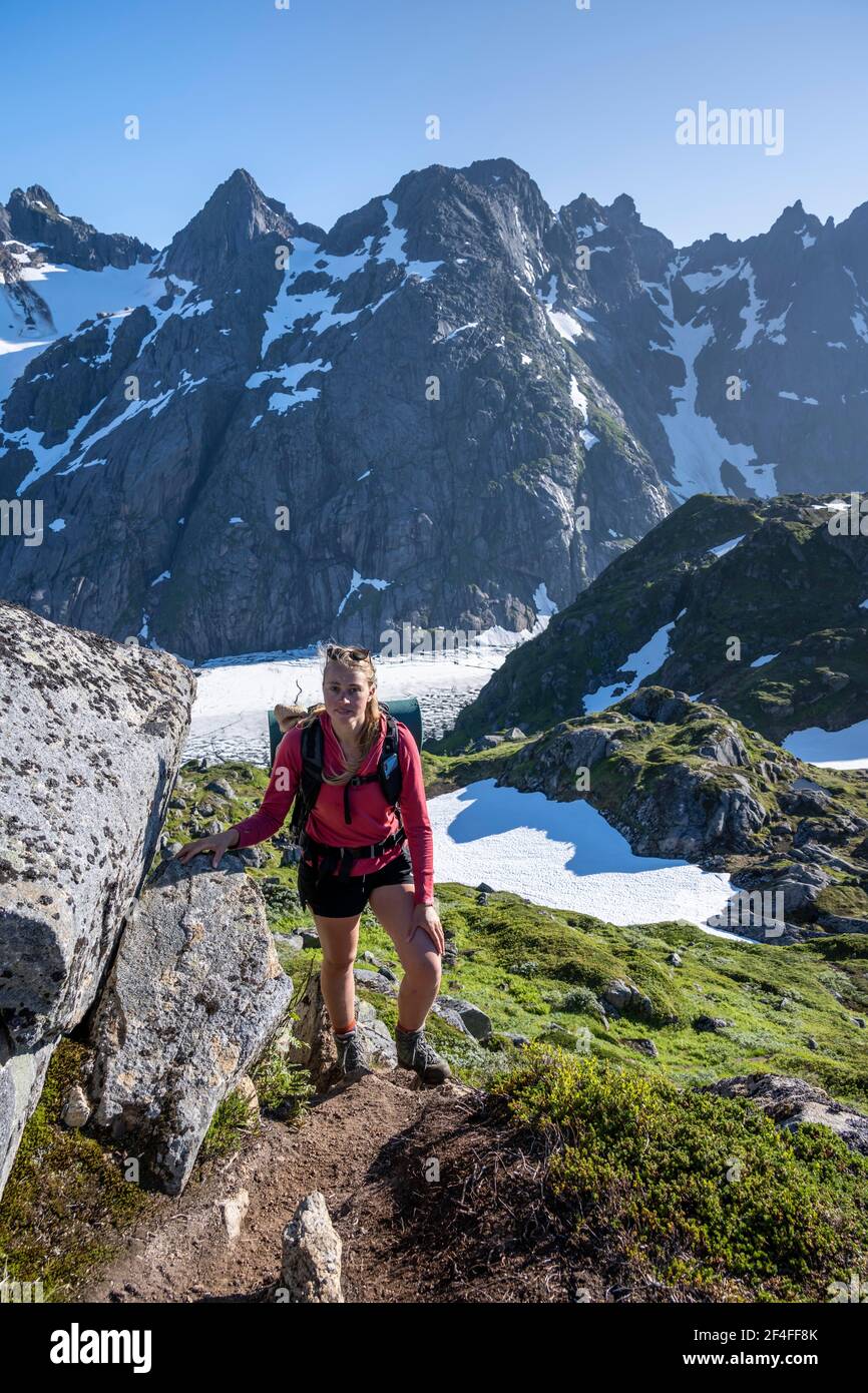 Jeune femme randonnée, montagnes et neige, randonnée jusqu'à Trollfjord Hytta, à Trollfjord, Lofoten, Nordland, Norvège Banque D'Images