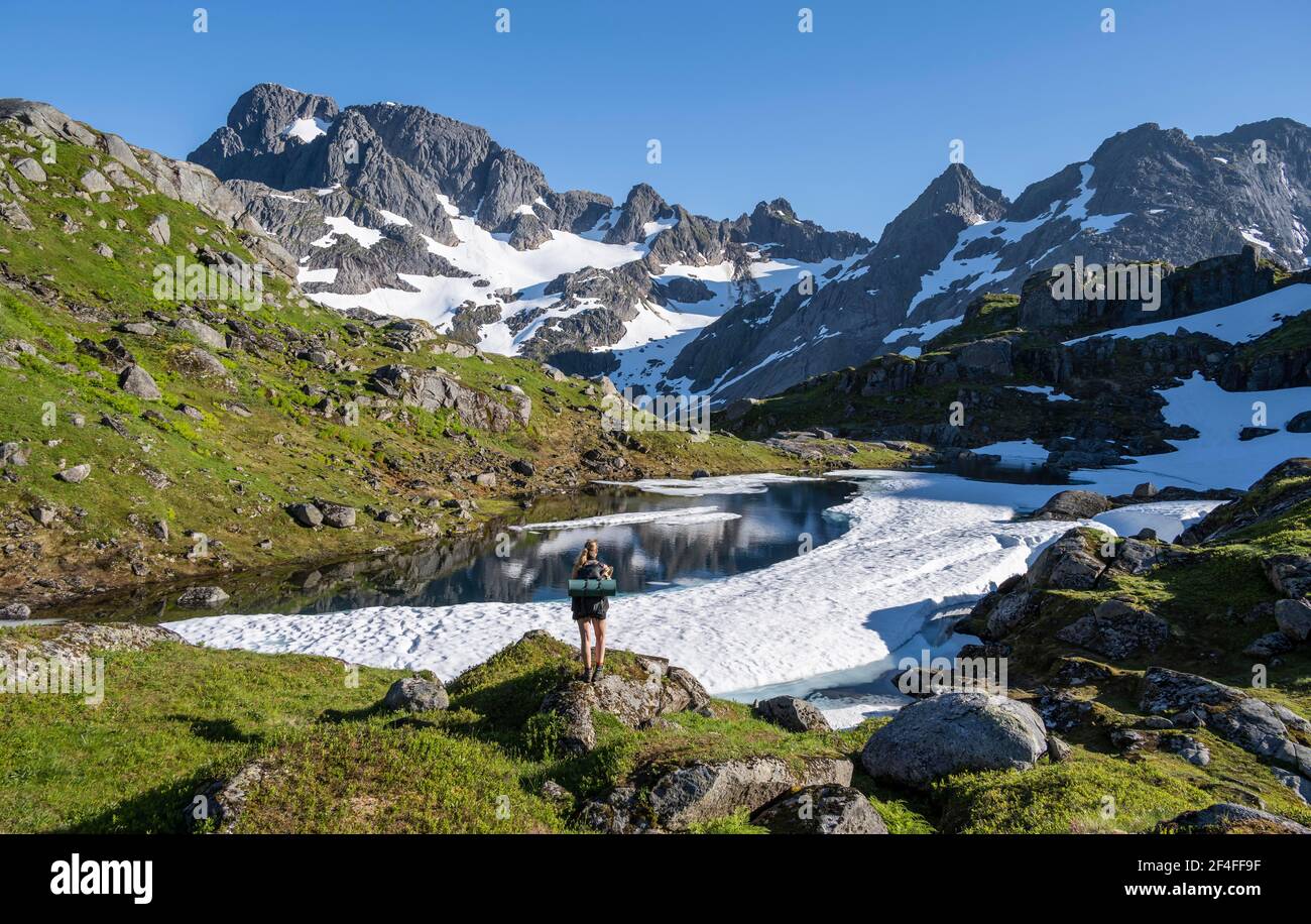 Jeune femme randonnée, montagnes et neige, randonnée jusqu'à Trollfjord Hytta, à Trollfjord, Lofoten, Nordland, Norvège Banque D'Images