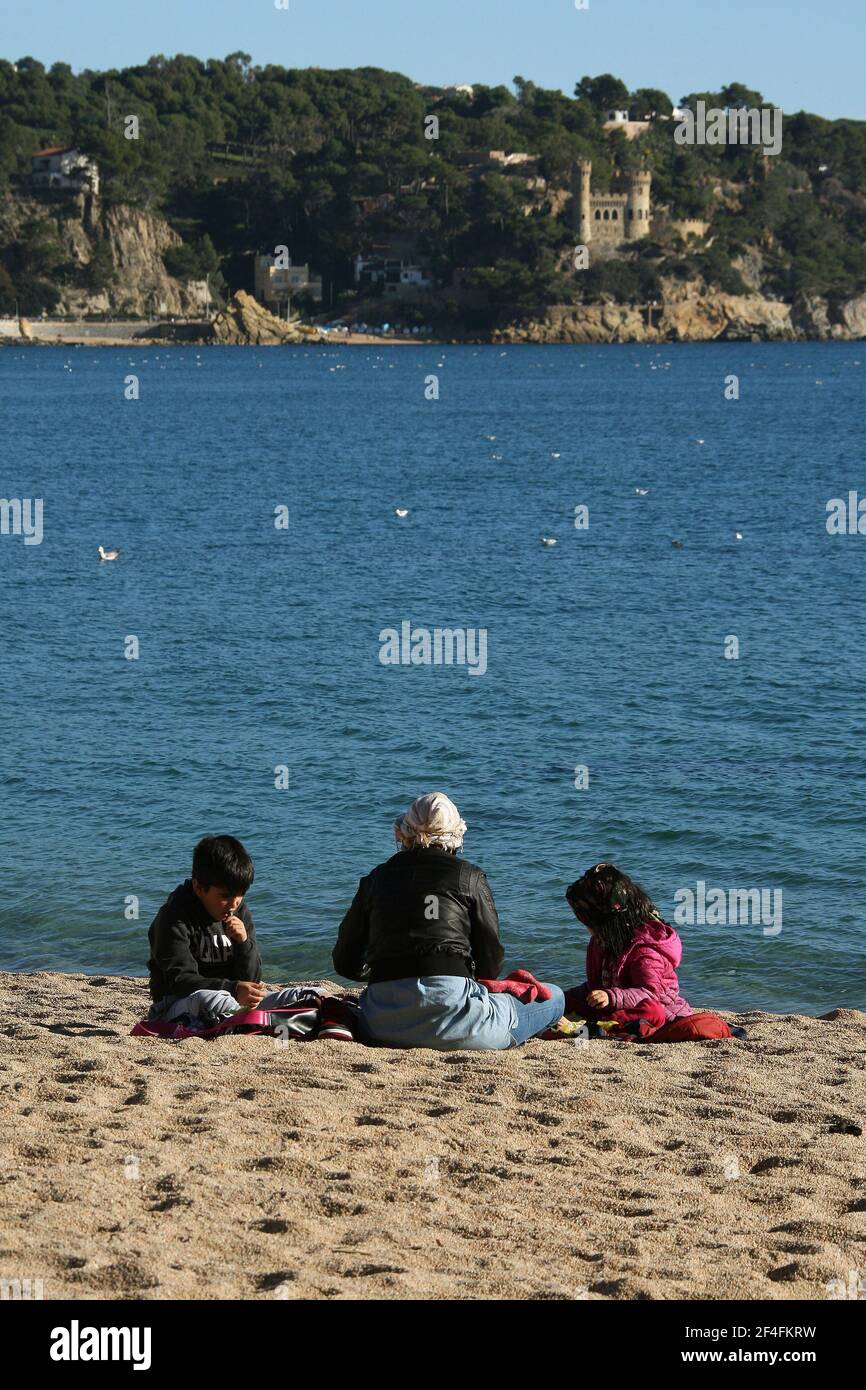 Une famille s'est assise sur la plage dans la ville balnéaire De Lloret de Mar sur la Costa Brava près de Calella En Catalogne Espagne UE 2019 Banque D'Images