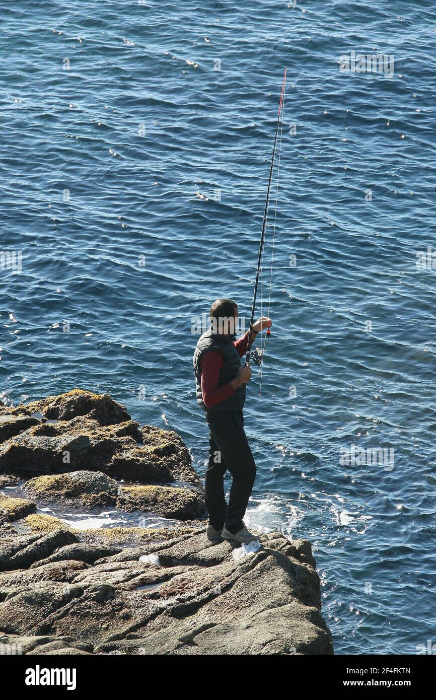 Un pêcheur sur un rocher dans la ville balnéaire de Lloret de Mar sur la Costa Brava près de Calella in Catalogne Espagne UE 2019 Banque D'Images