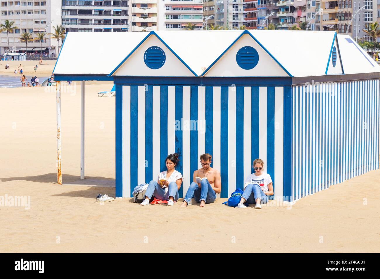 Las Palmas, Grande Canarie, Îles Canaries, Espagne. 21 mars 2021. Les gens lisant sur une plage tranquille de la ville à Las Palmas sur Gran Canaria. Les vacances d'été à l'étranger sont encore en doute pour les ressortissants britanniques car le gouvernement s'inquiète de la hausse des cas dans d'autres pays européens. Dans un effort pour éviter une augmentation des cas Covid pendant les vacances de Pâques, Gran Canaria, Tenerife et Fuerteventura ont été déplacés du niveau 2 au niveau 3 Covid restrictions à partir du 26 mars. Même les habitants voyageant sur les vols et les ferries entre les îles auront besoin d'un PCR négatif. Banque D'Images