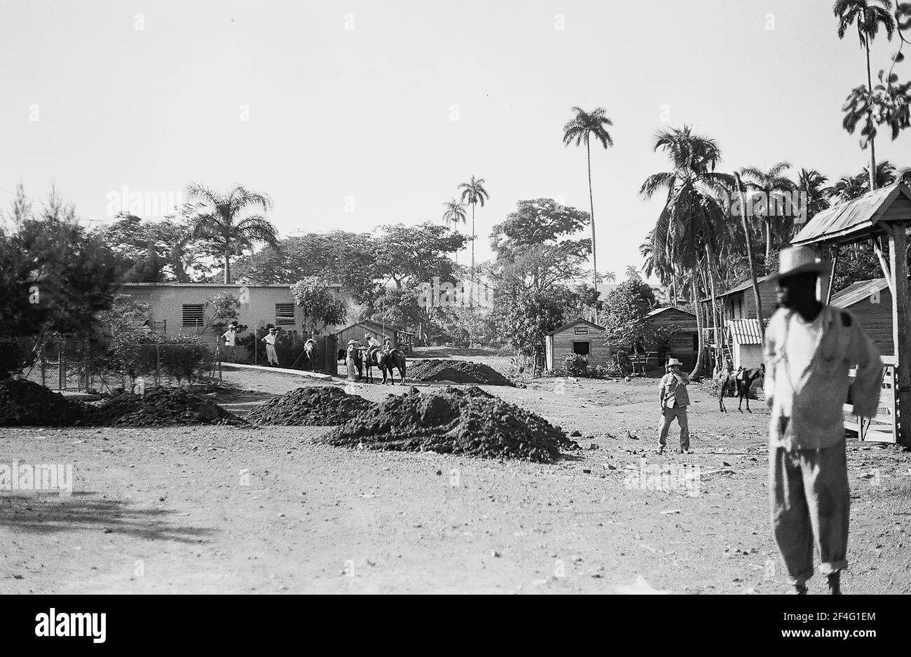 Les gens se trouvent dans un champ avec des débris visibles, Biran, Cuba, province de Holguin, 1963. De la collection de photographies Deena Stryker. () Banque D'Images