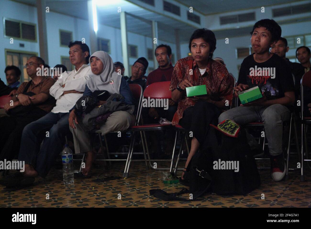 Des spectaculaires mangeant au cours de la représentation de huit heures de wayang kulis 'Sudamala' au Sasono Hinggil Theatre à Yogyakarta, dans le centre de Java, en Indonésie. Le théâtre traditionnel de marionnettes connu sous le nom de wayang kulis est répandu sur les îles de Java et Bali en Indonésie. Chaque exécution de wayang kulit se poursuit environ huit heures par nuit sans intermissions et un seul maître de marionnettes (dalang) conduit toutes les marionnettes projetées sur un écran en lin et les vocalise avec des voix différentes. Bien que l'Indonésie soit le pays musulman le plus peuplé du monde, les histoires et les personnages de wayang ku Banque D'Images