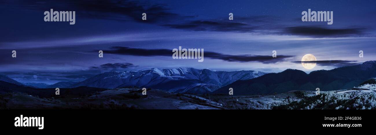 paysage rural montagneux au printemps la nuit. beau paysage sous un ciel avec des nuages en pleine lune. colline couverte d'herbe rollin Banque D'Images paysage rural montagneux au printemps la nuit. beau paysage sous un ciel avec des nuages en pleine lune. colline couverte d'herbe rollin Banque D'Images