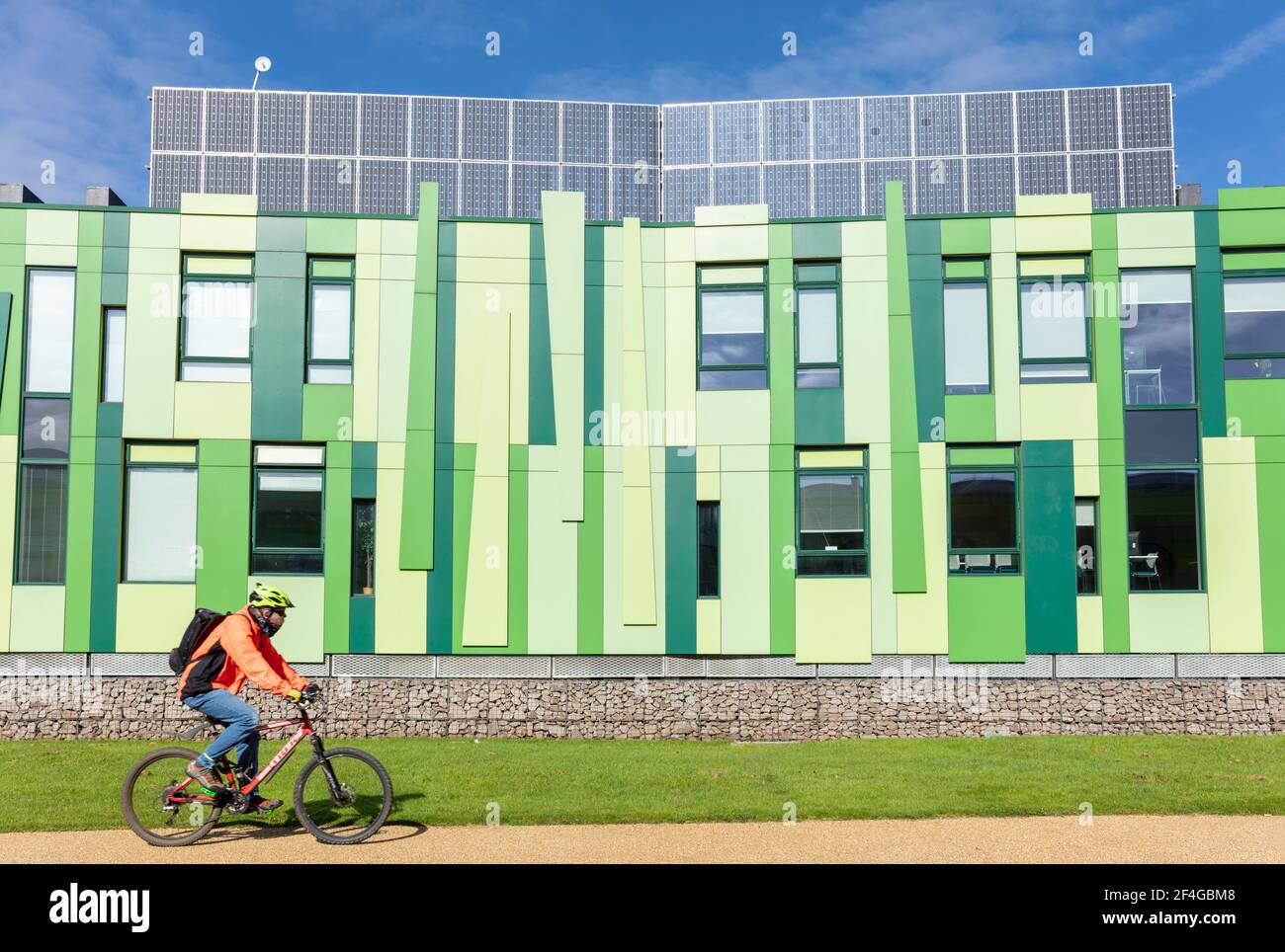 Cycliste passant devant les bâtiments n° 1 du parc scientifique de Nottingham à Nottingham University science Park Nottingham Notinghamshire Angleterre GB Royaume-Uni Europe Banque D'Images