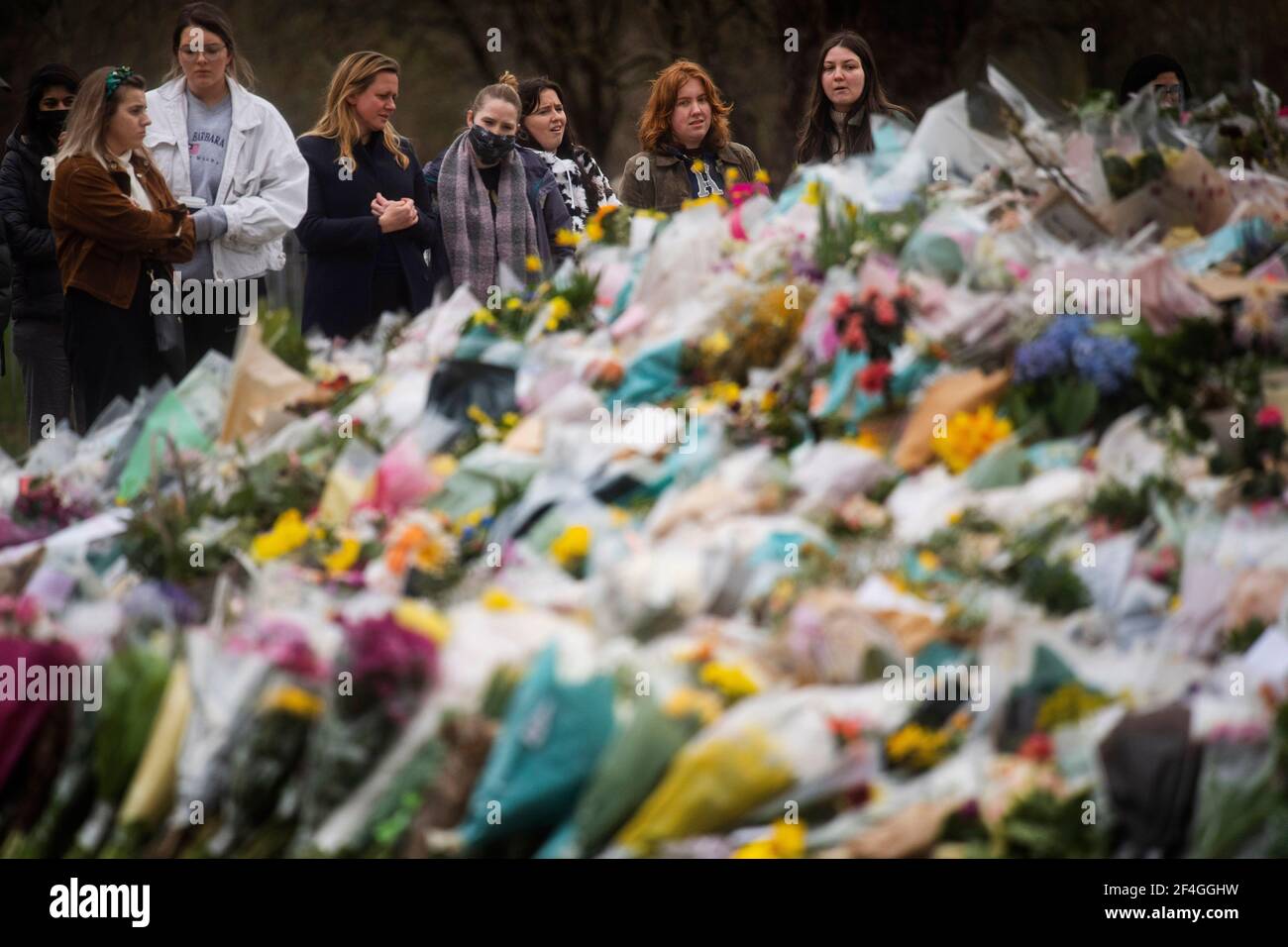 Un groupe de femmes regarde les hommages floraux laissés au kiosque de Clapham Common, Londres, pour Sarah Everard. Le PC Wayne Couzens, 48 ans, a comparu devant le Old Bailey de Londres, accusé d'enlèvement et de meurtre de l'enfant de 33 ans. Date de la photo: Dimanche 21 mars 2021. Banque D'Images