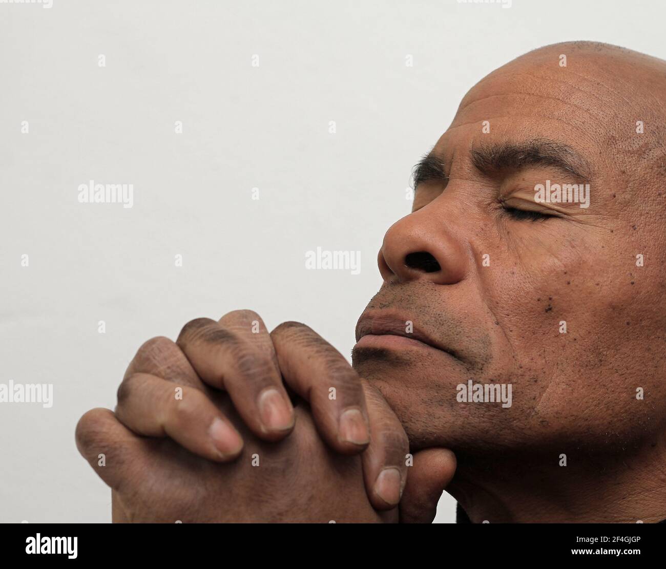 Homme priant à dieu avec les mains ensemble Caraïbes homme priant avec photo d'arrière-plan blanche Banque D'Images