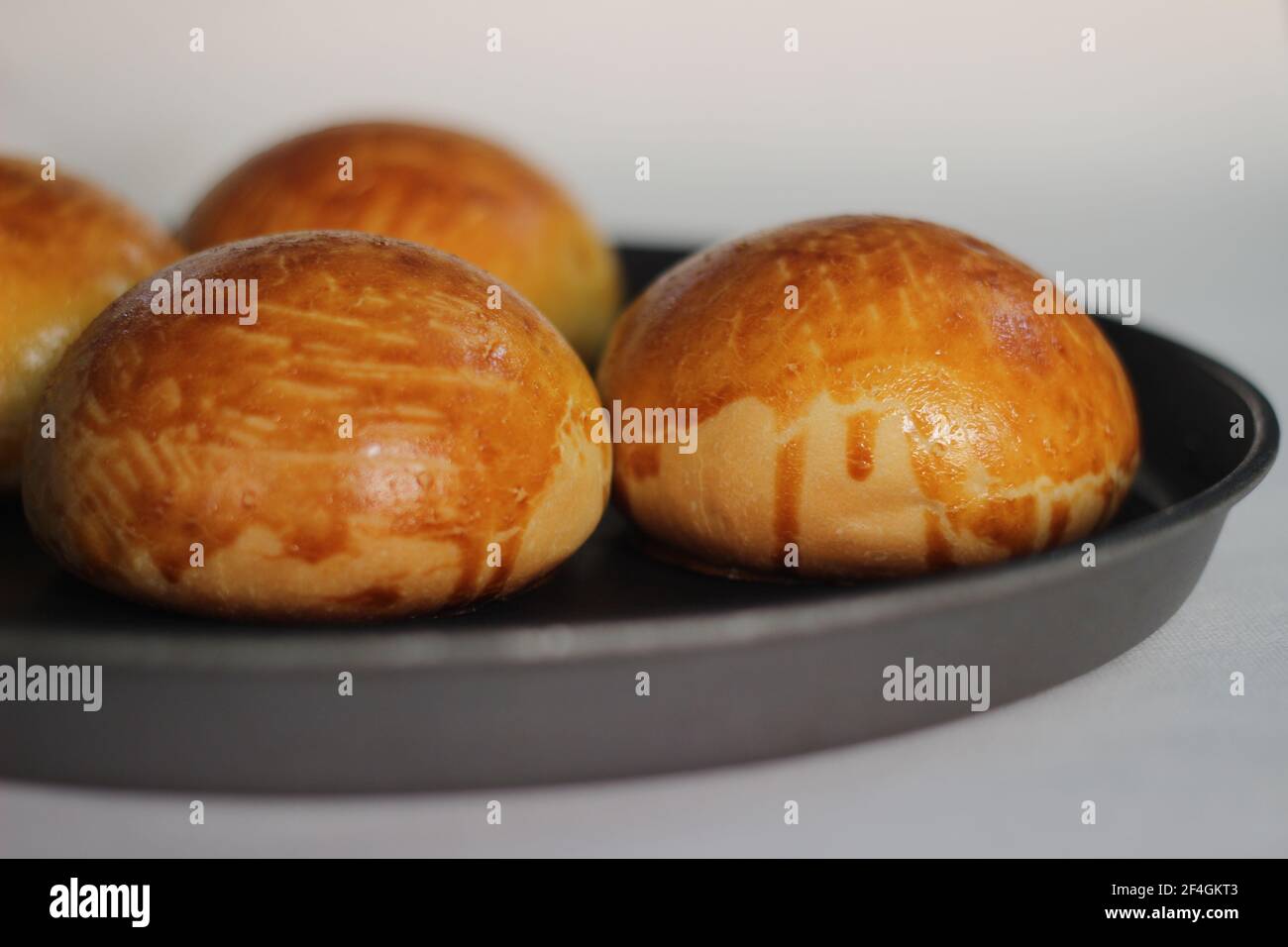 Le lavage aux œufs s'est mal passé lors de la cuisson de petits pains de Brioche, pain de levure française enrichi de lait, de beurre et d'œufs. Prise de vue sur fond blanc Banque D'Images