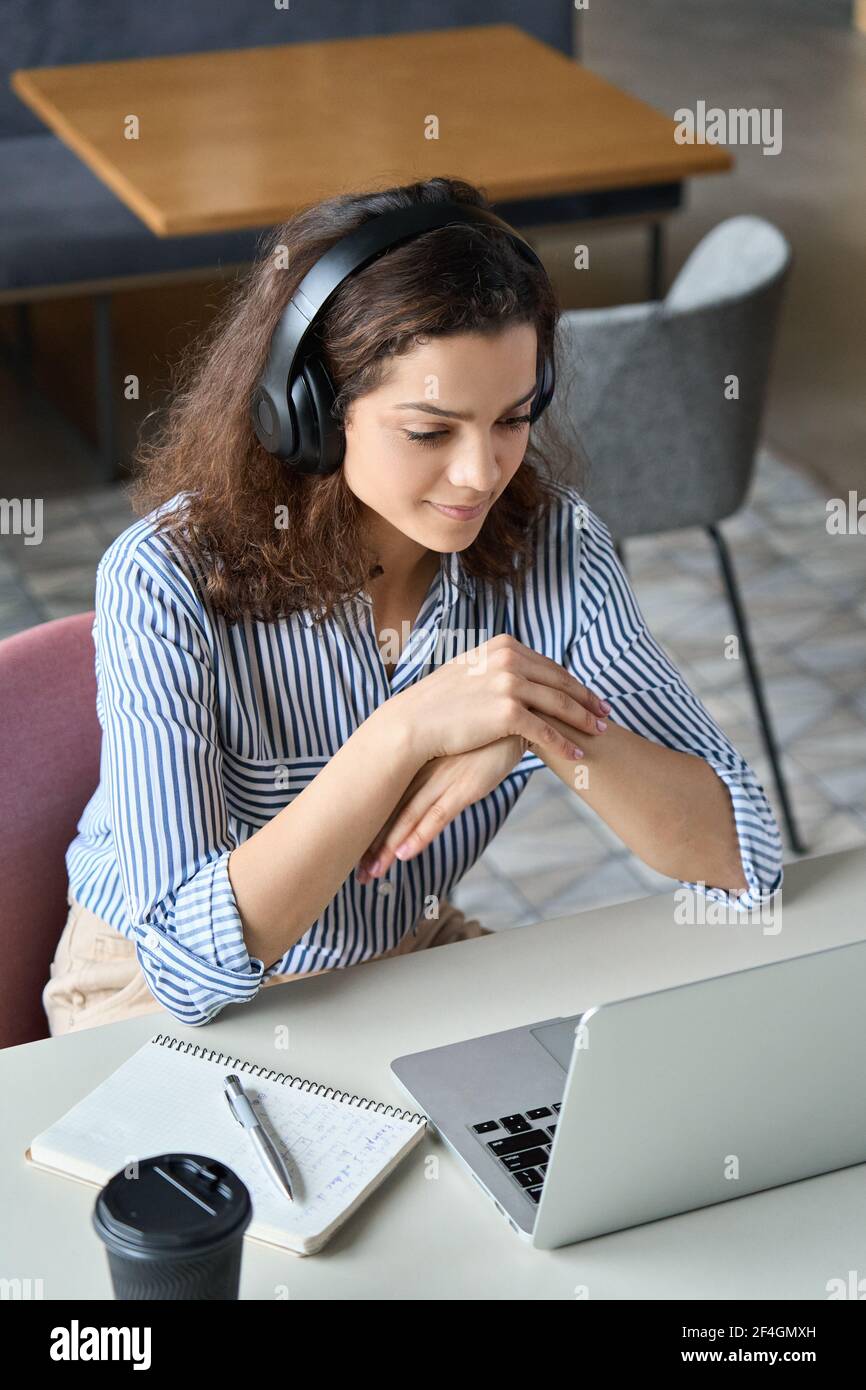 Une étudiante hispanique portant un casque et regardant des cours en ligne à distance. Banque D'Images