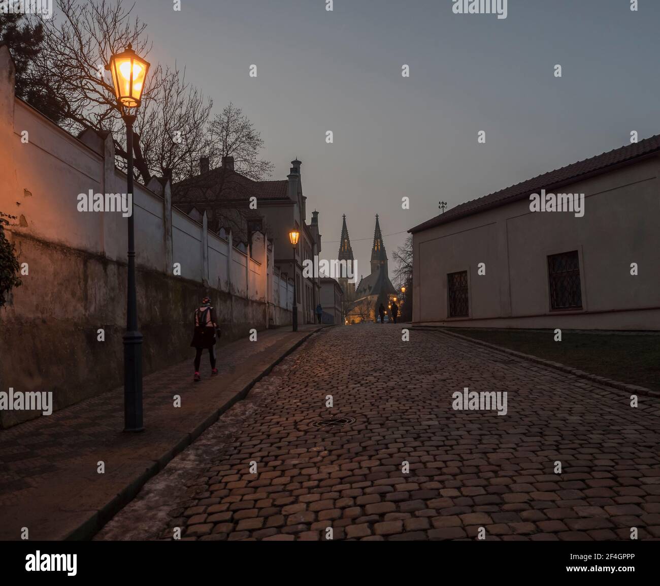 République tchèque, Prague, 23 février 2021 : vue nocturne de la rue pavée de Vysehrad avec lanternes et basilique illuminée Saint-Pierre et Paul Banque D'Images