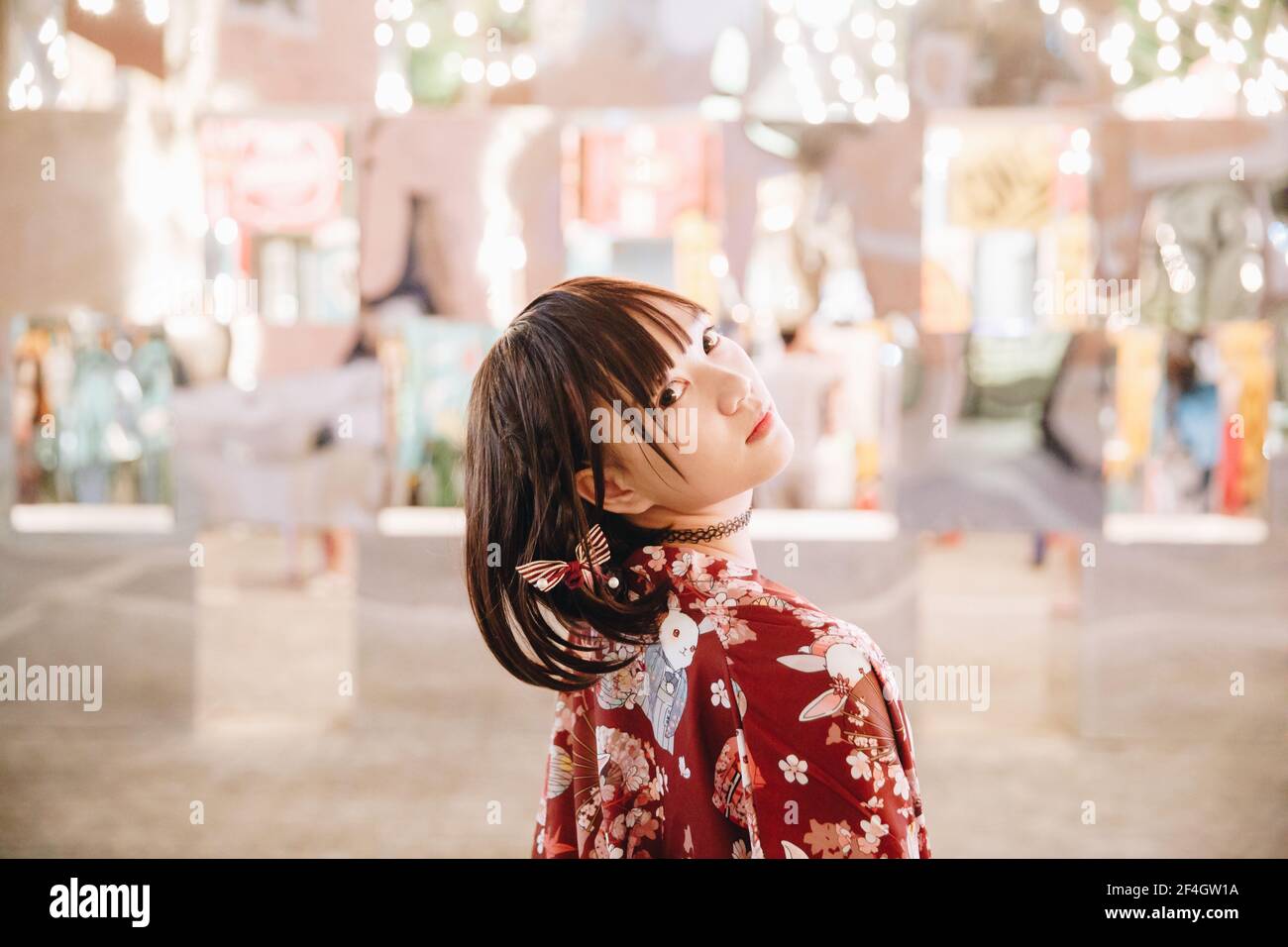 portrait de fille asiatique avec chemise blanche et jupe regardant en plein air urbain style vintage film Banque D'Images