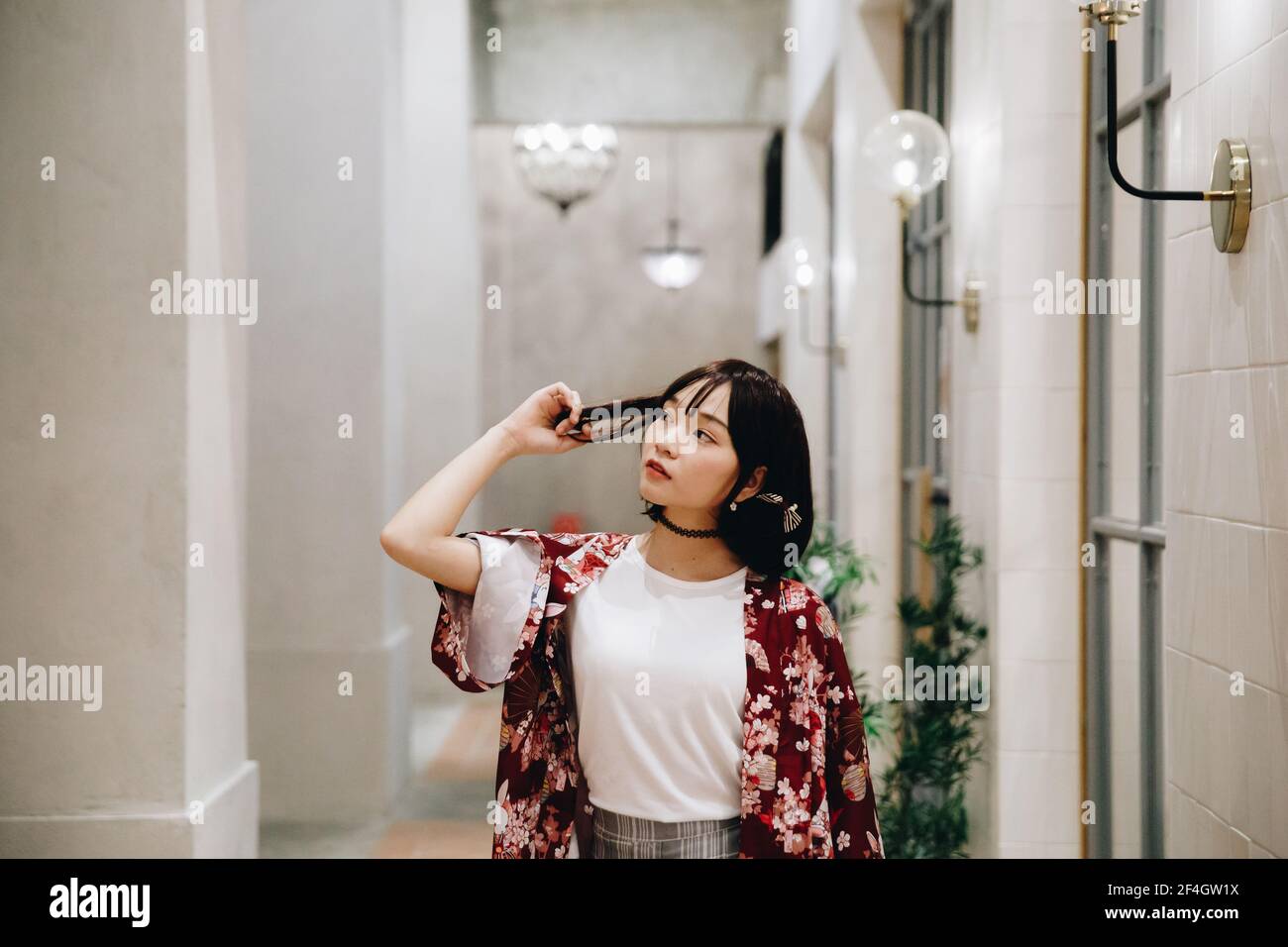 portrait de fille asiatique avec chemise blanche et jupe regardant en plein air urbain style vintage film Banque D'Images